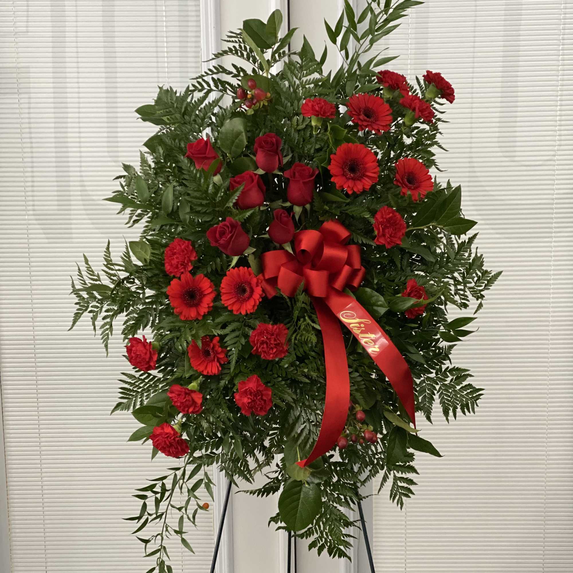 This Sympathy Standing Spray, in beautiful red, is a touching symbol of