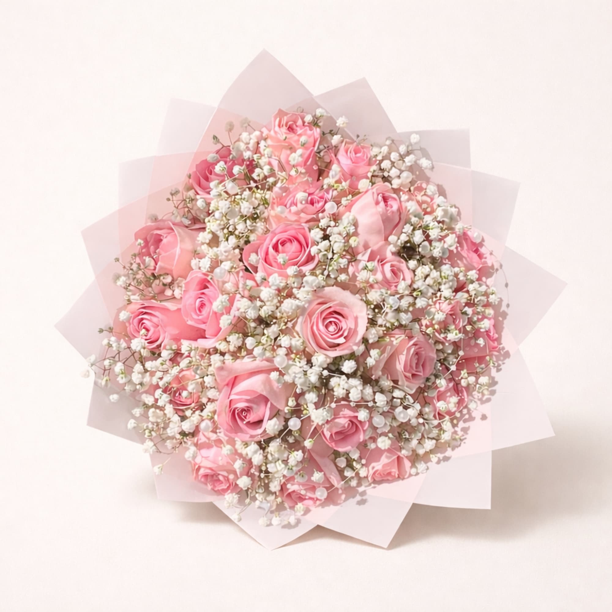 Pink rose bouquet with white baby's breath in pale wrapping