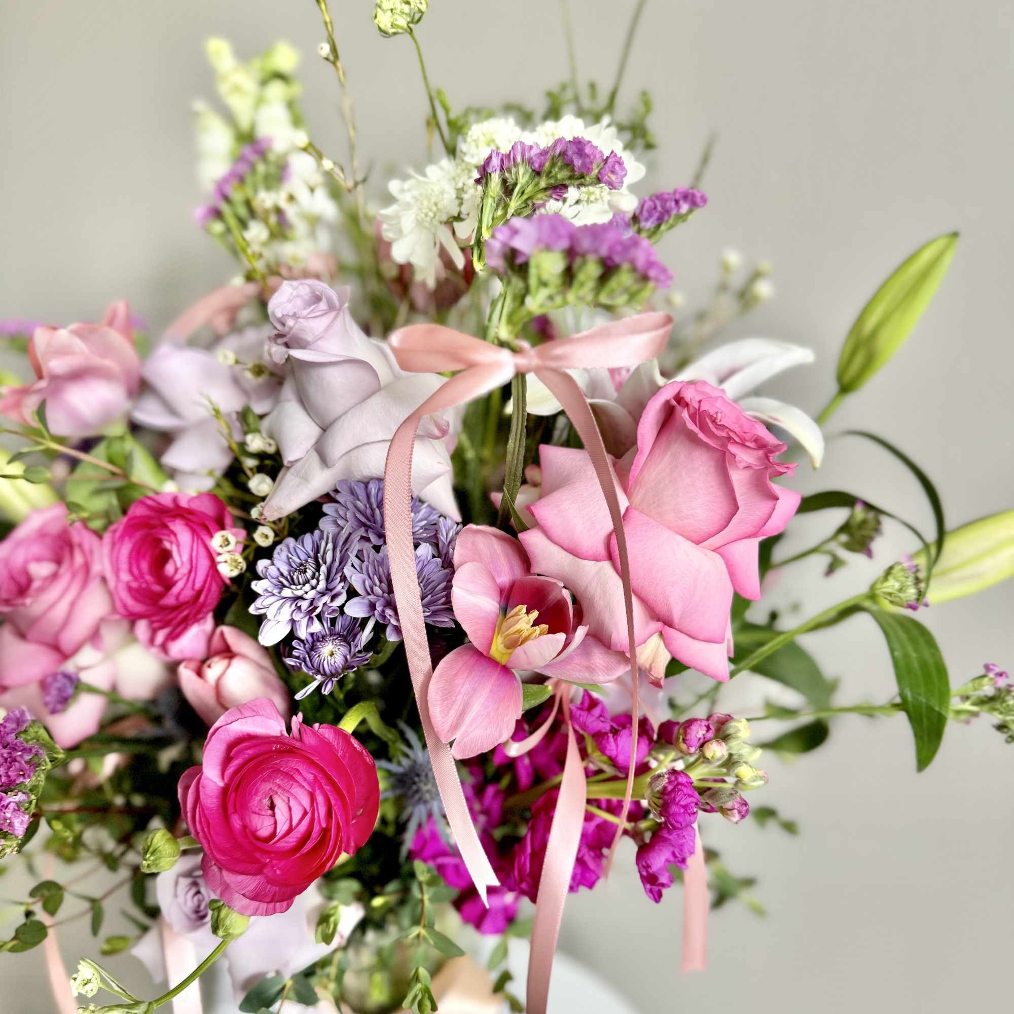 Pink and lavender bouquet with roses, tulips, and ribbon