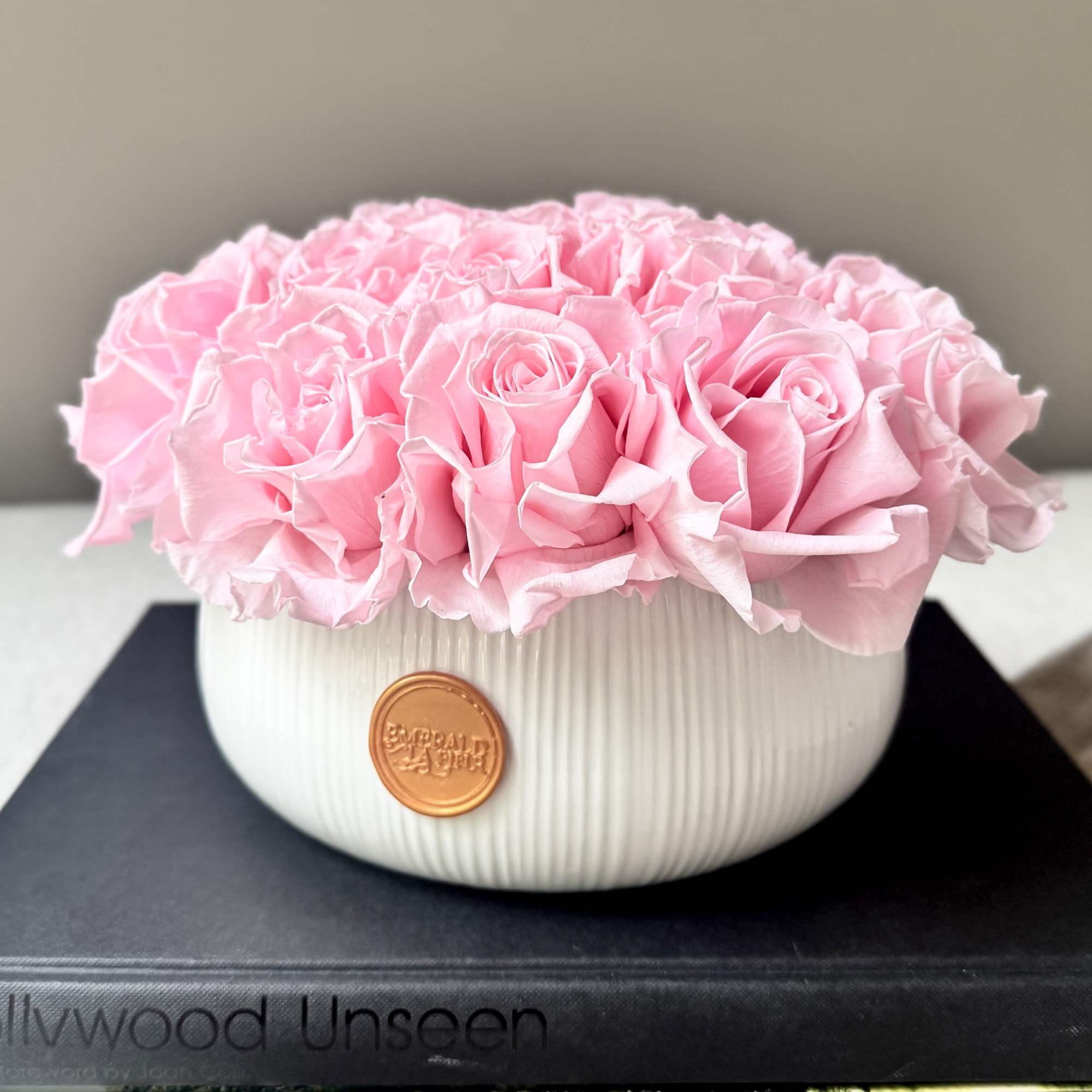 Pink roses arranged in a white ribbed bowl