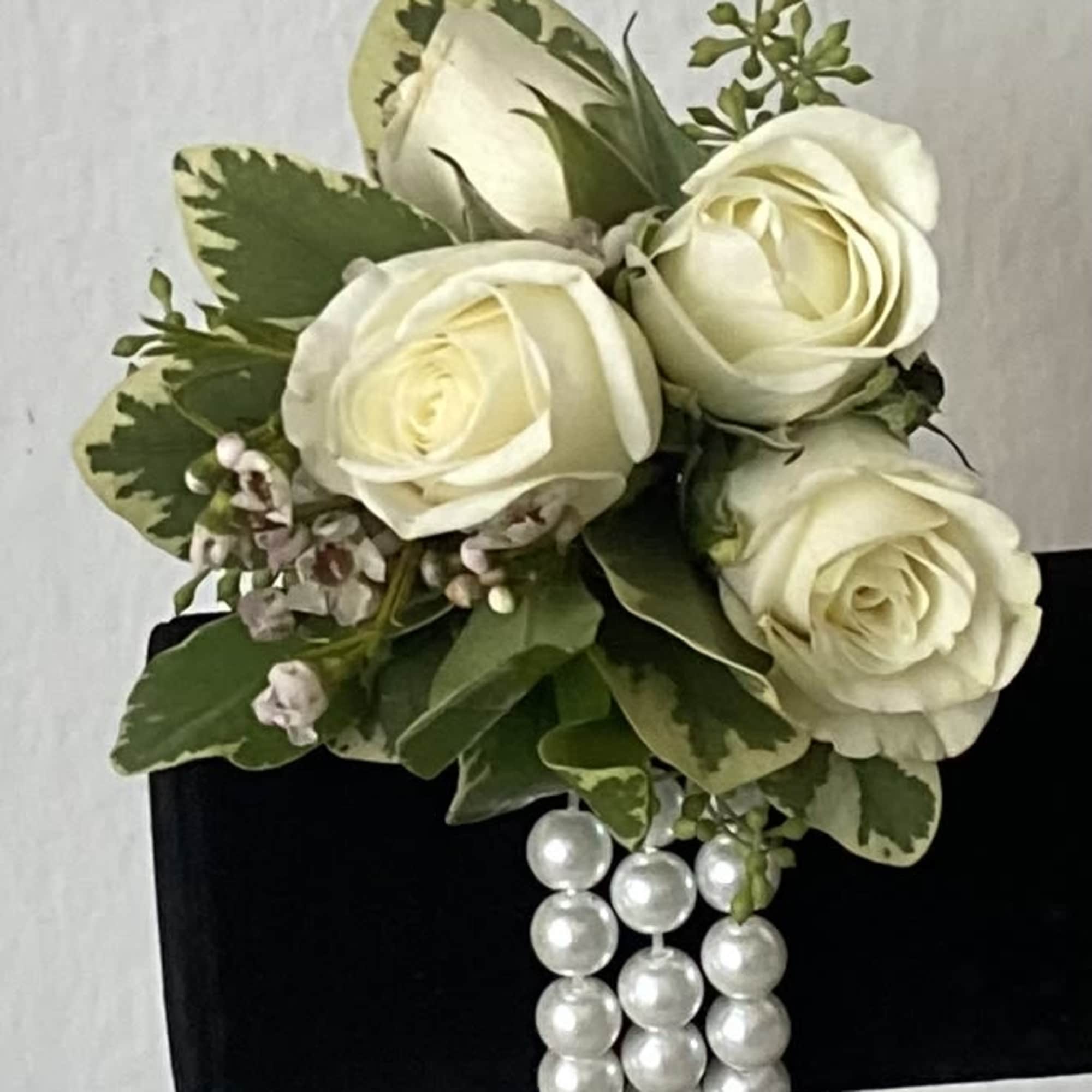 White rose corsage with pearl strands on a black wristlet
