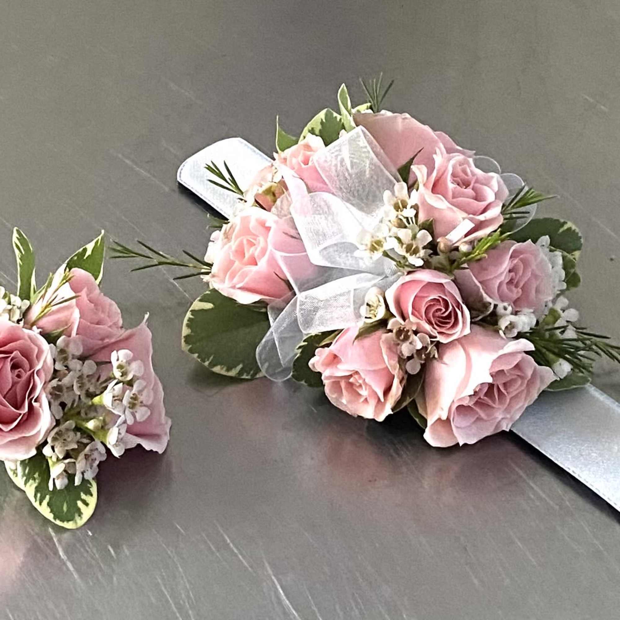 Pink rose corsage and boutonniere with white ribbon