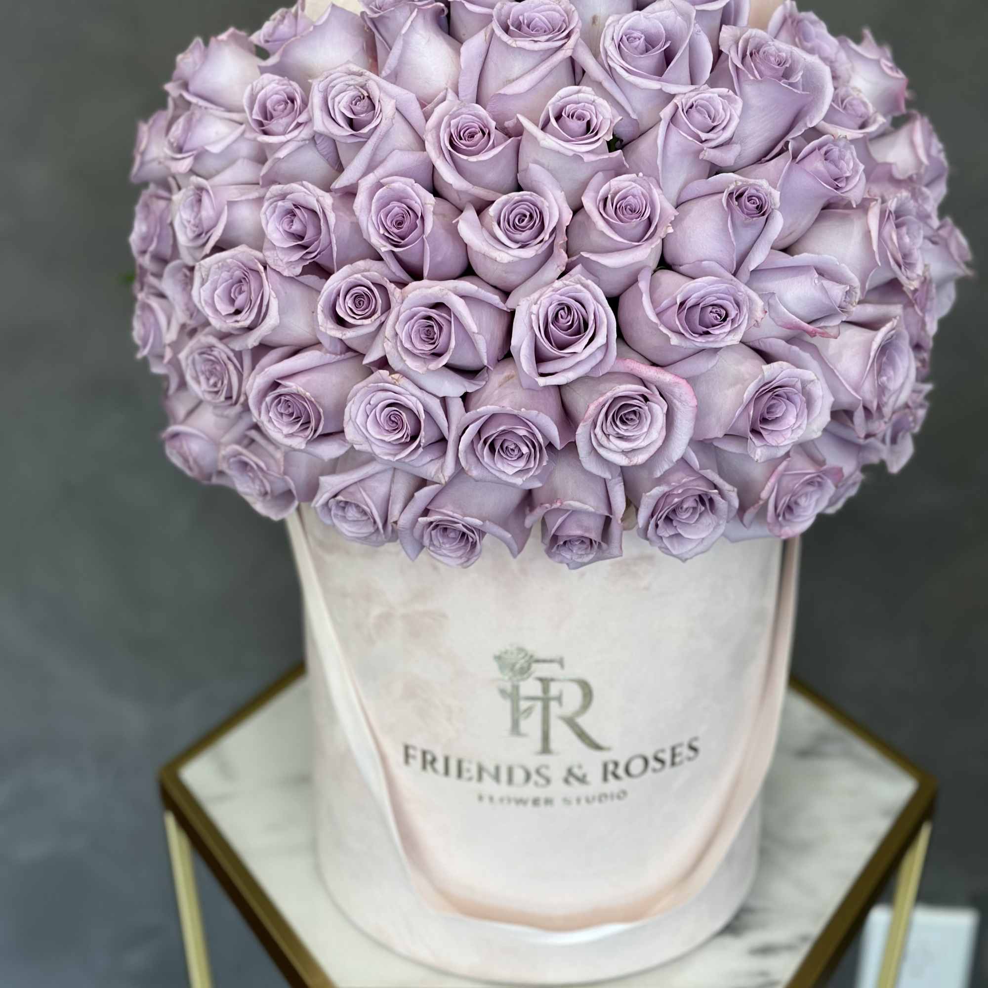Bouquet of lavender roses in a pale hatbox