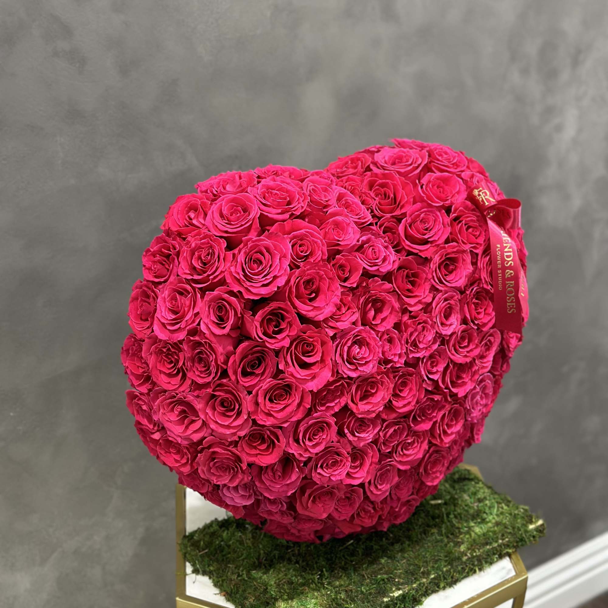 Heart-shaped bouquet of hot pink roses on a stand