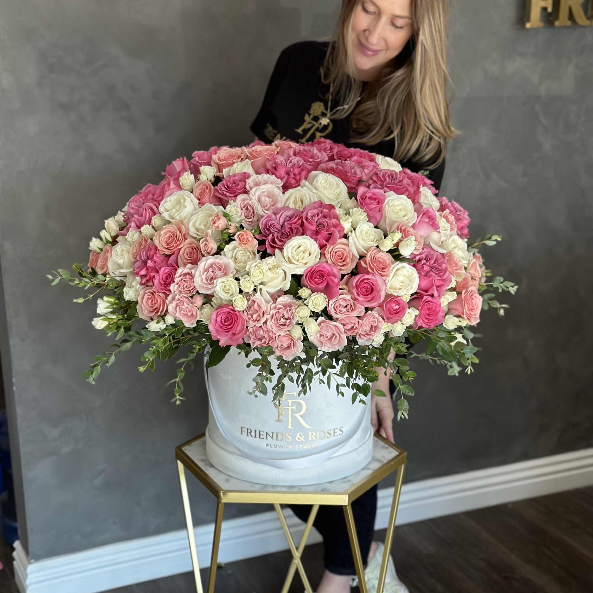 Large pink and white rose arrangement in a round box