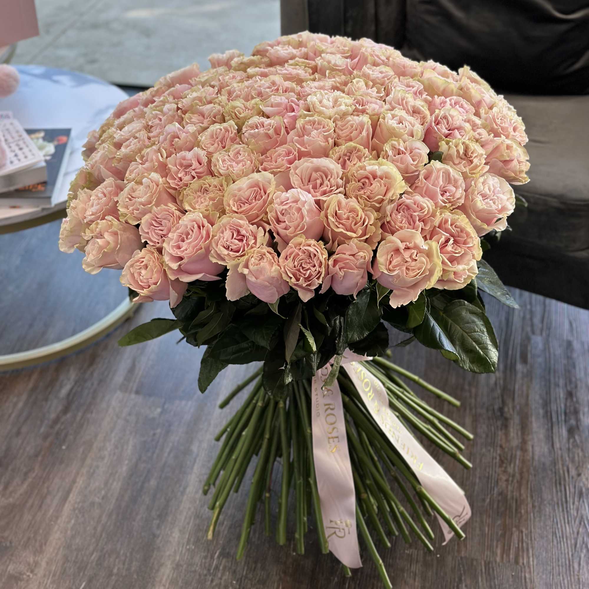 Large bouquet of pale pink roses with ribbon tied stems