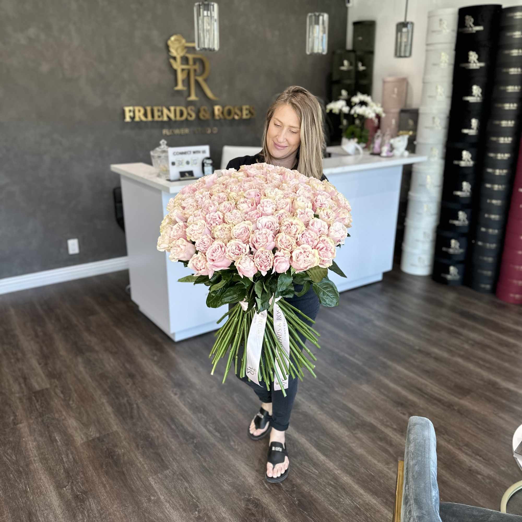 Woman holding a large bouquet of pale pink roses