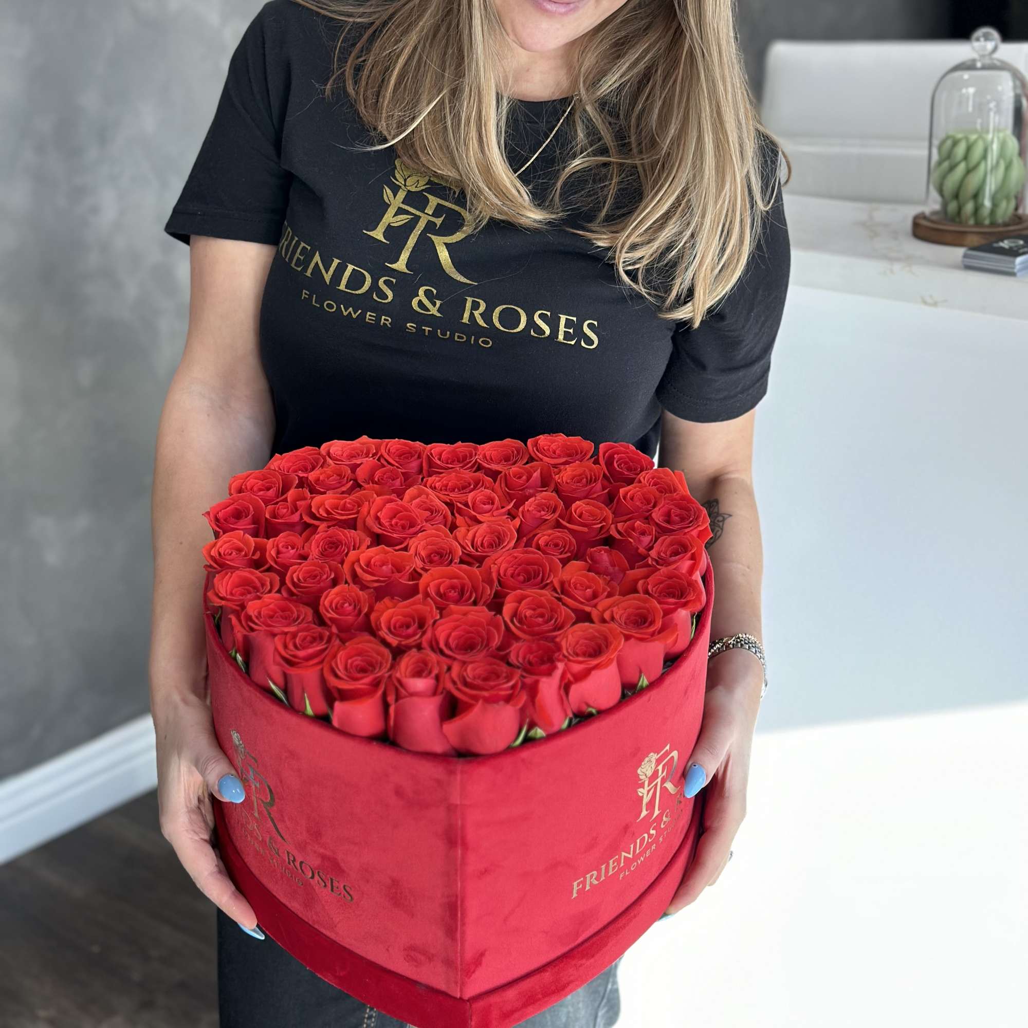 Woman holding a heart-shaped box filled with red roses