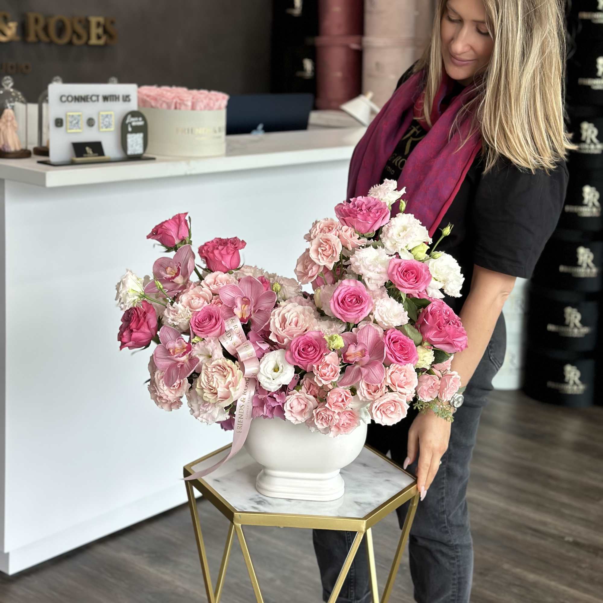 Large pink and white flower arrangement in a white vase