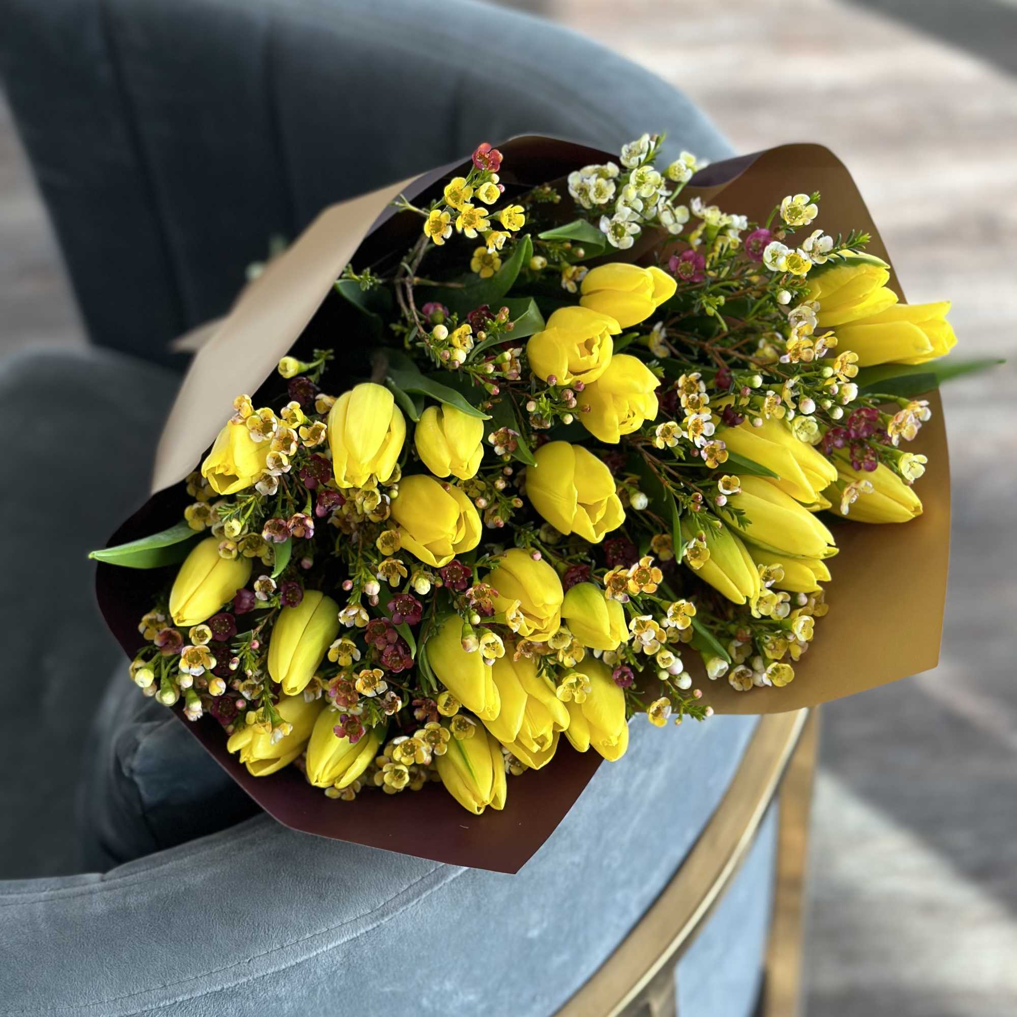 Bouquet of yellow tulips with small white and pink filler flowers