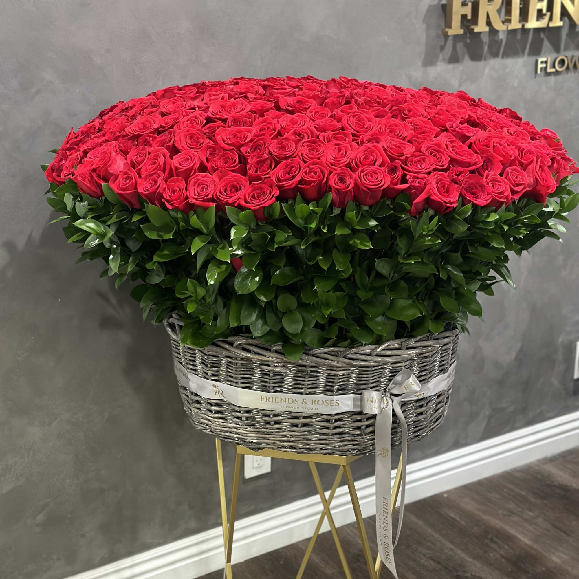 Large basket arrangement of red roses with a ribbon bow