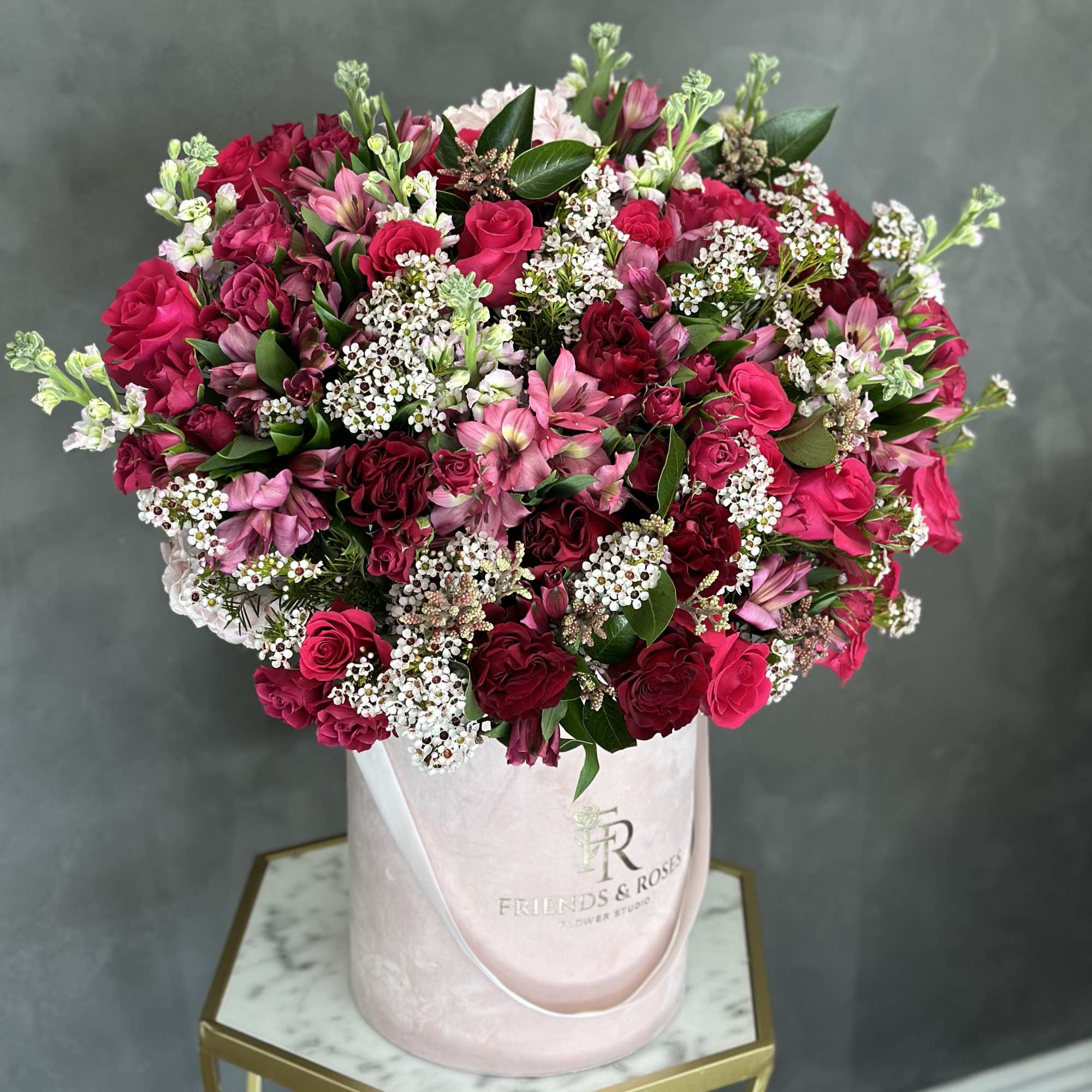 Bouquet of pink and red roses in a pale pink hatbox