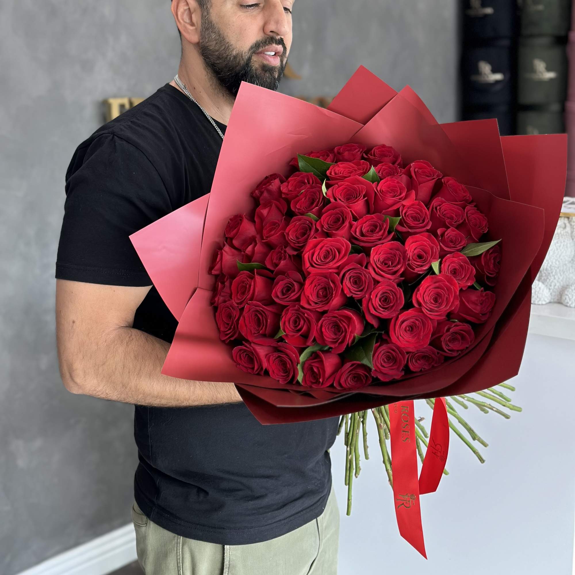 Large bouquet of red roses wrapped in red paper