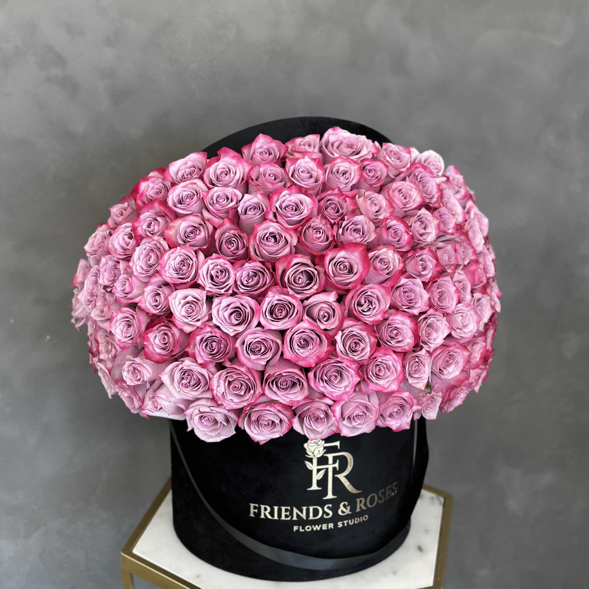 Large round bouquet of pink roses in a black hat box