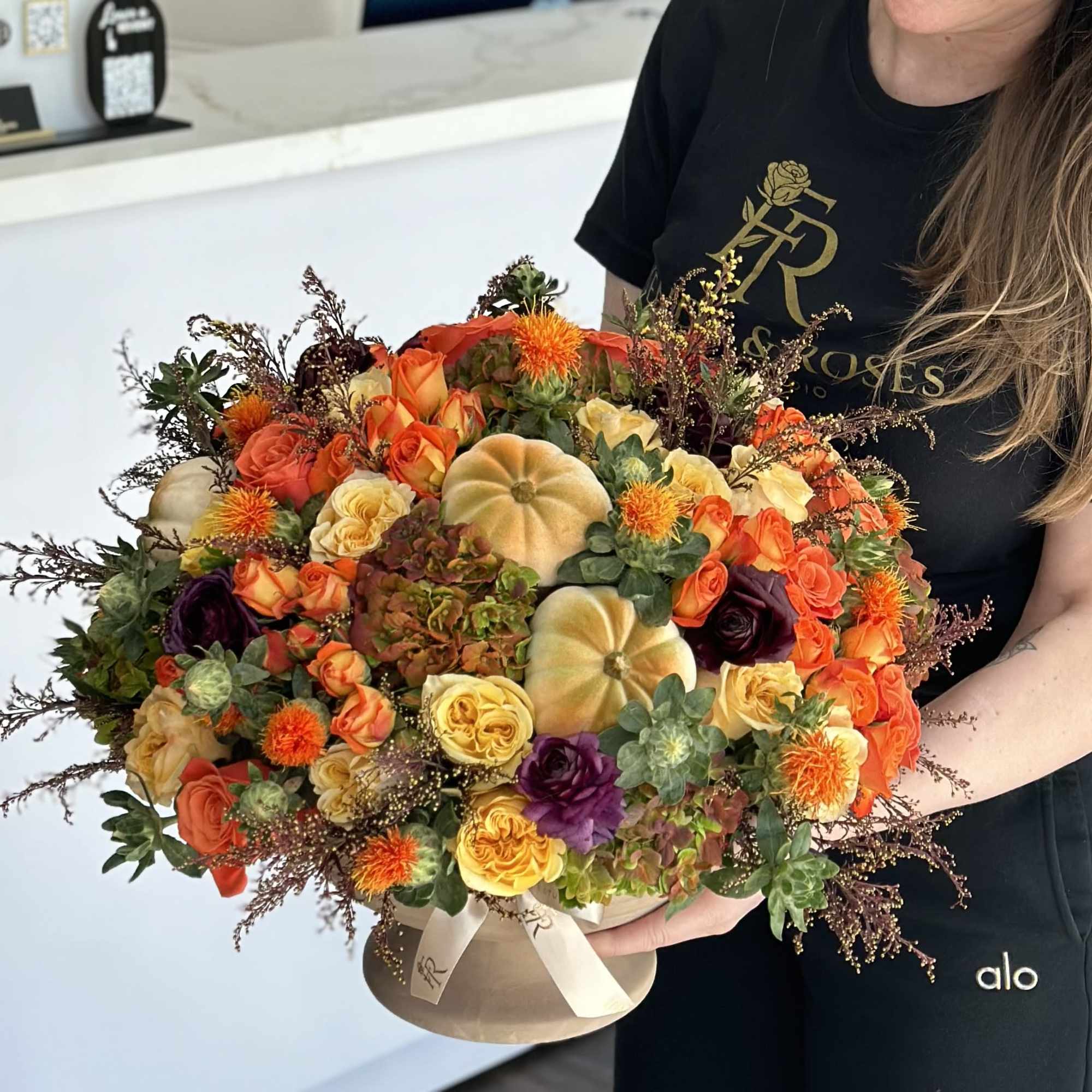 Large autumn bouquet with orange and yellow roses in a round box