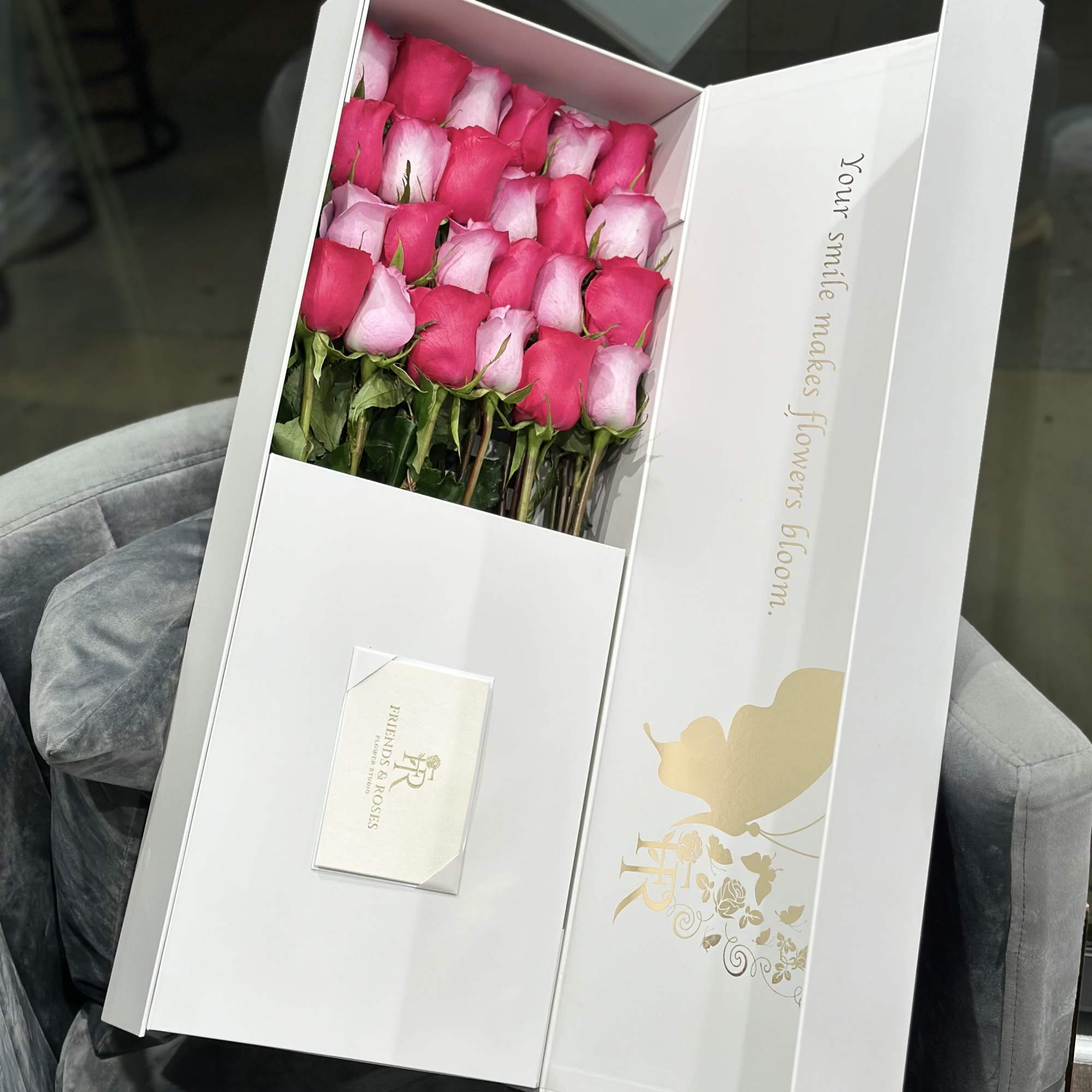 Box of pink and hot pink roses with a small card