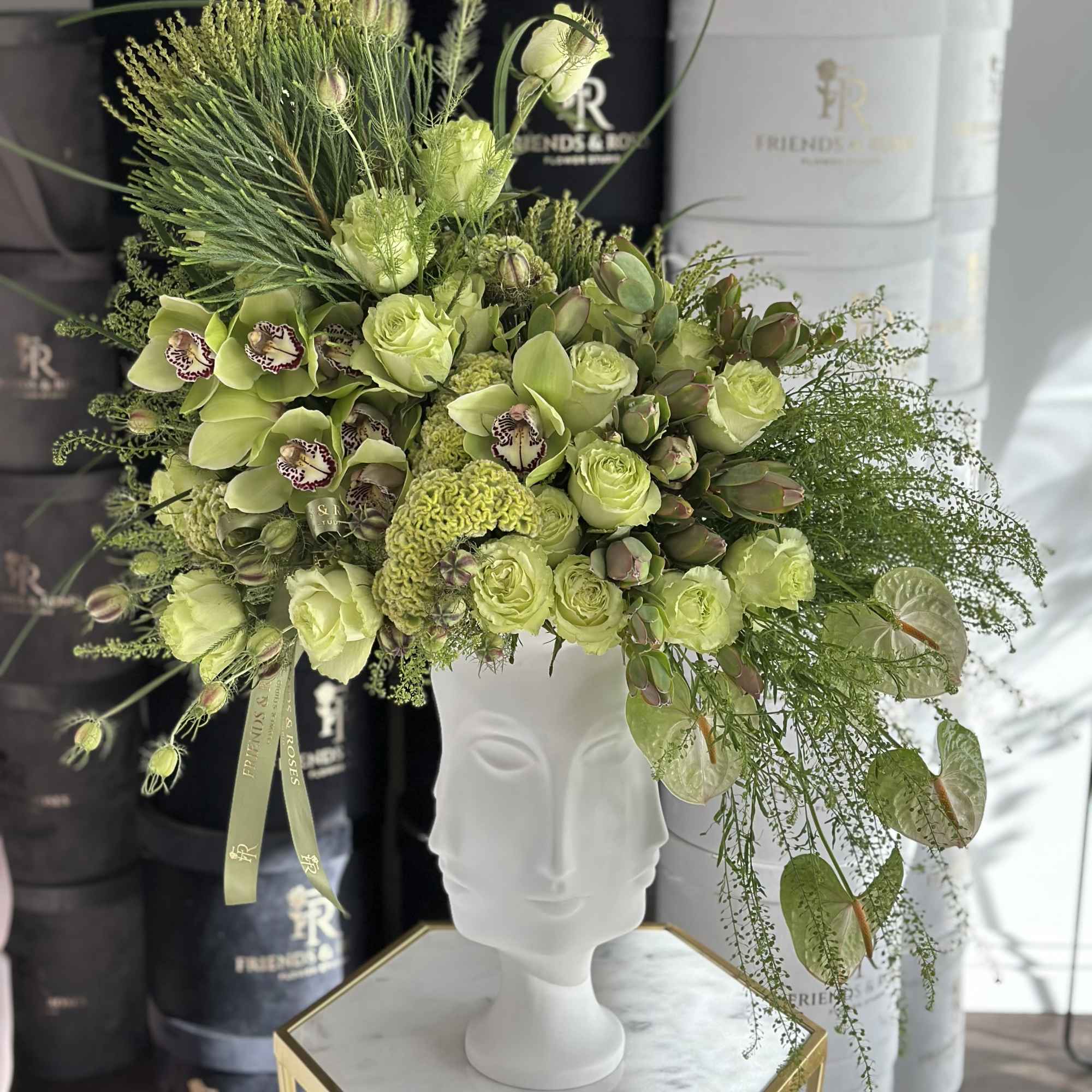 Lime-green floral arrangement in a white bust vase