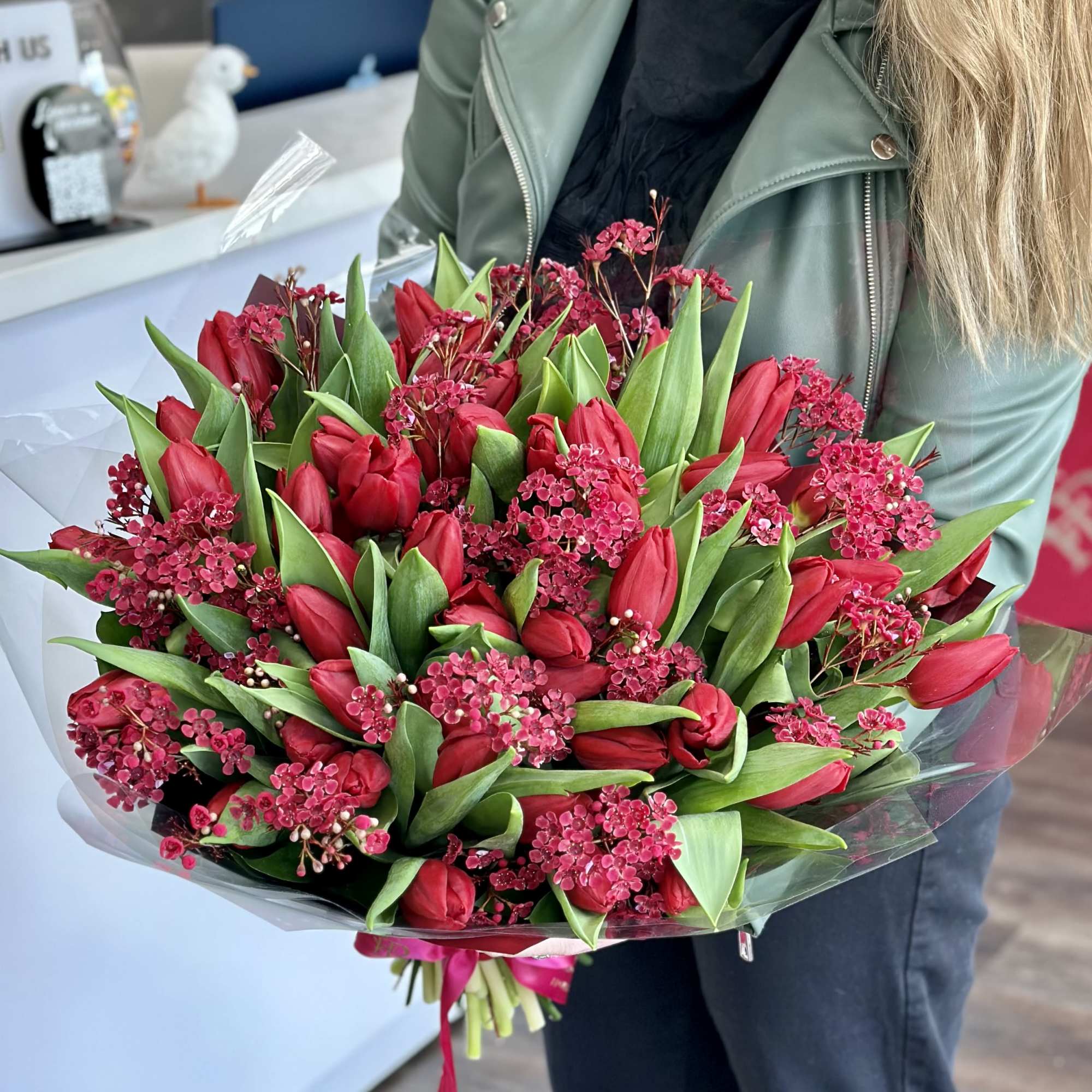 Bouquet of red tulips and pink filler flowers wrapped in clear plastic, photo 2 of 3