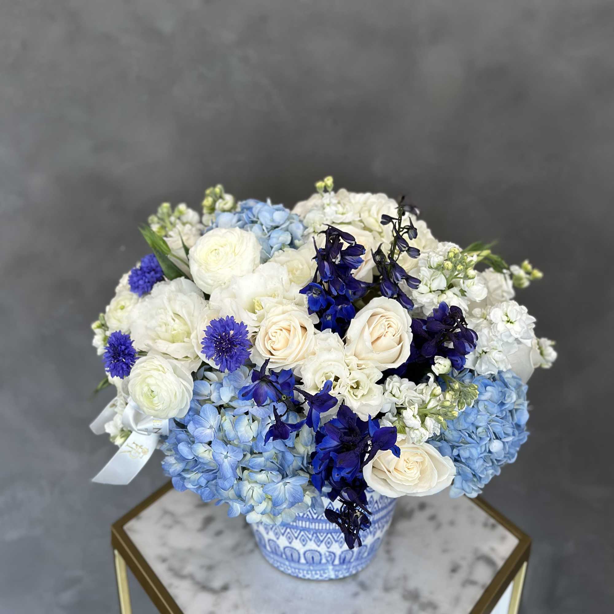 Blue and white floral arrangement in a patterned ceramic vase