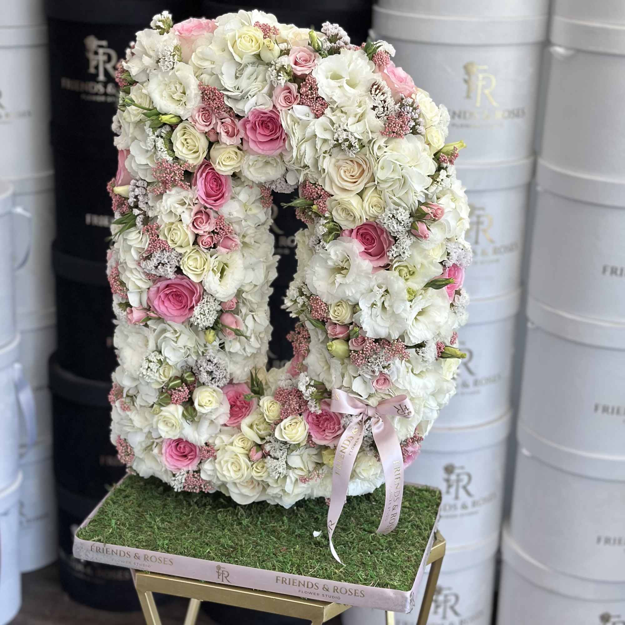 Large floral number-shaped arrangement in white and pink roses