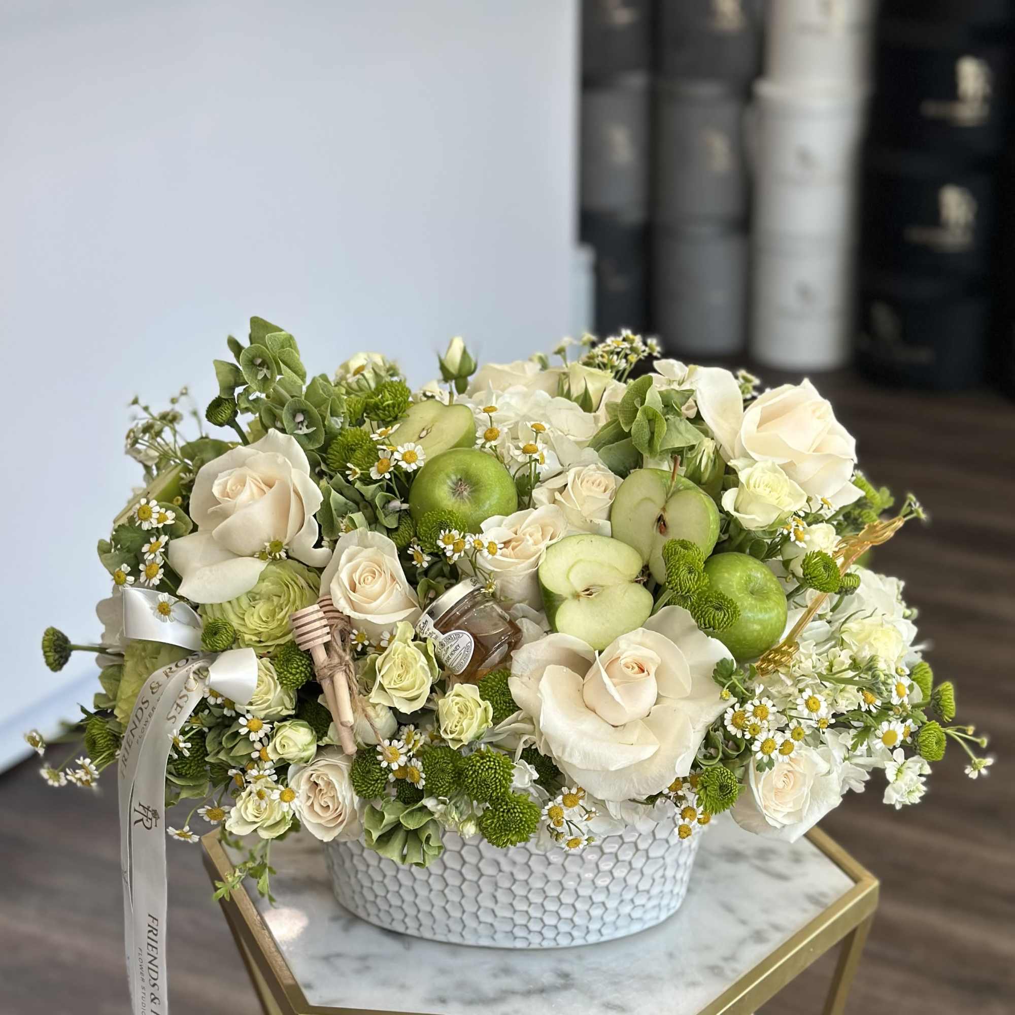 Cream roses and green apples in a white textured vase