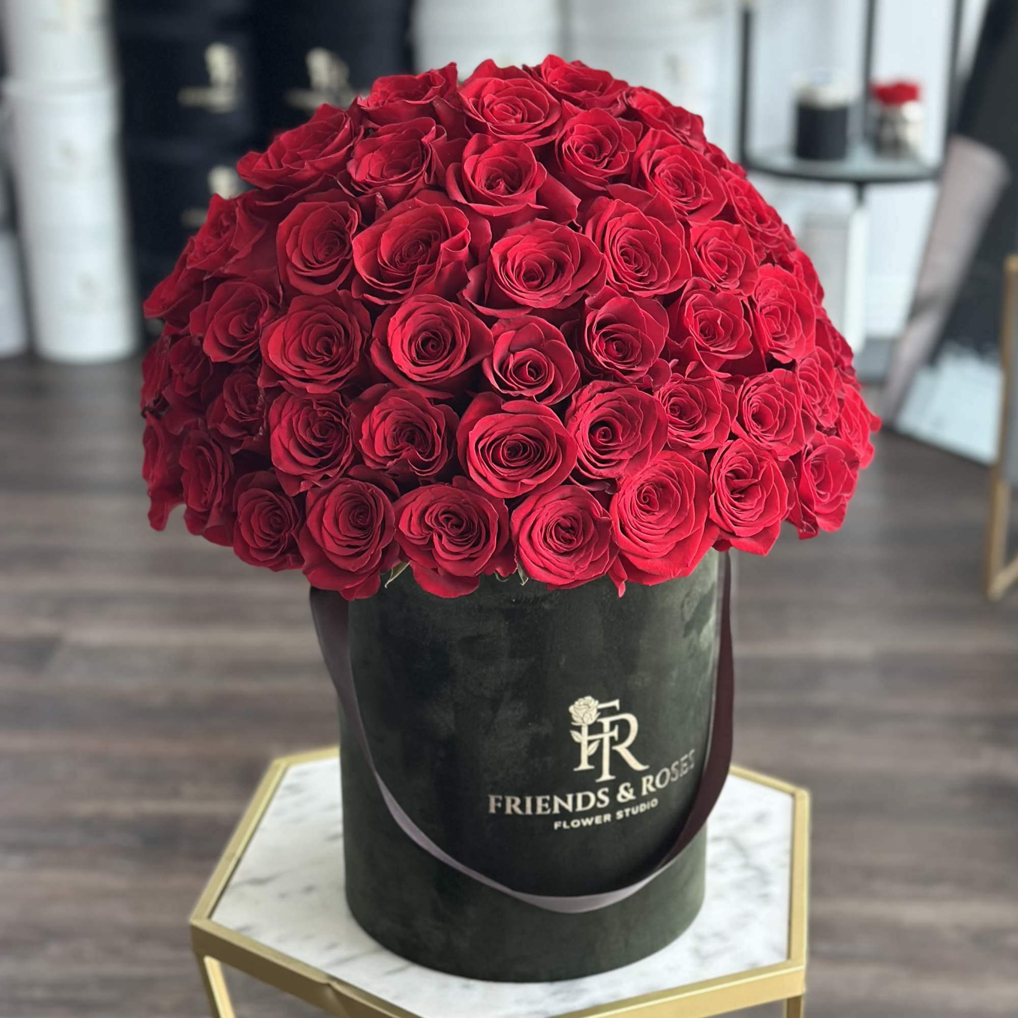 Large red rose arrangement in a black hat box