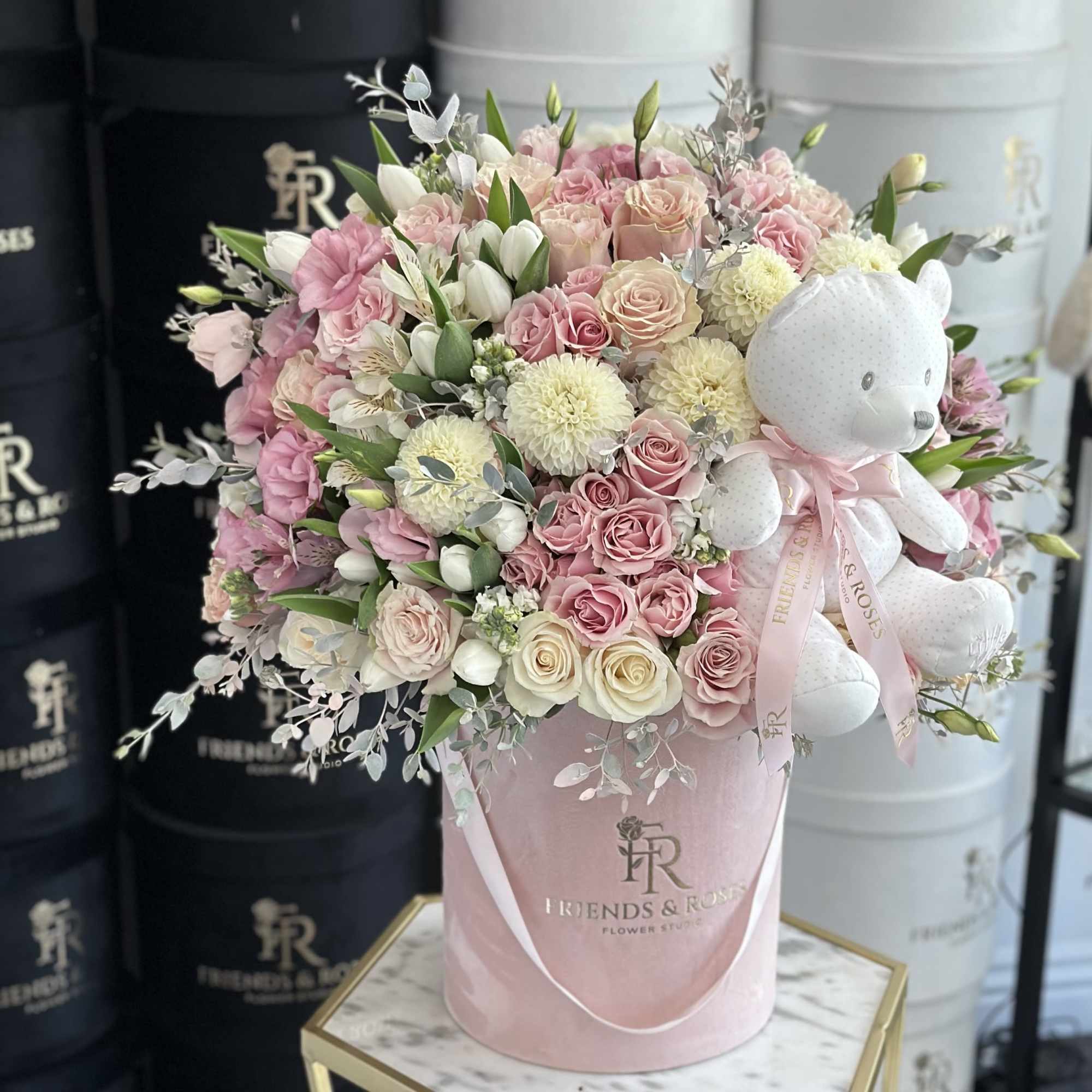 Pink and white rose bouquet in a pink hatbox with a teddy bear