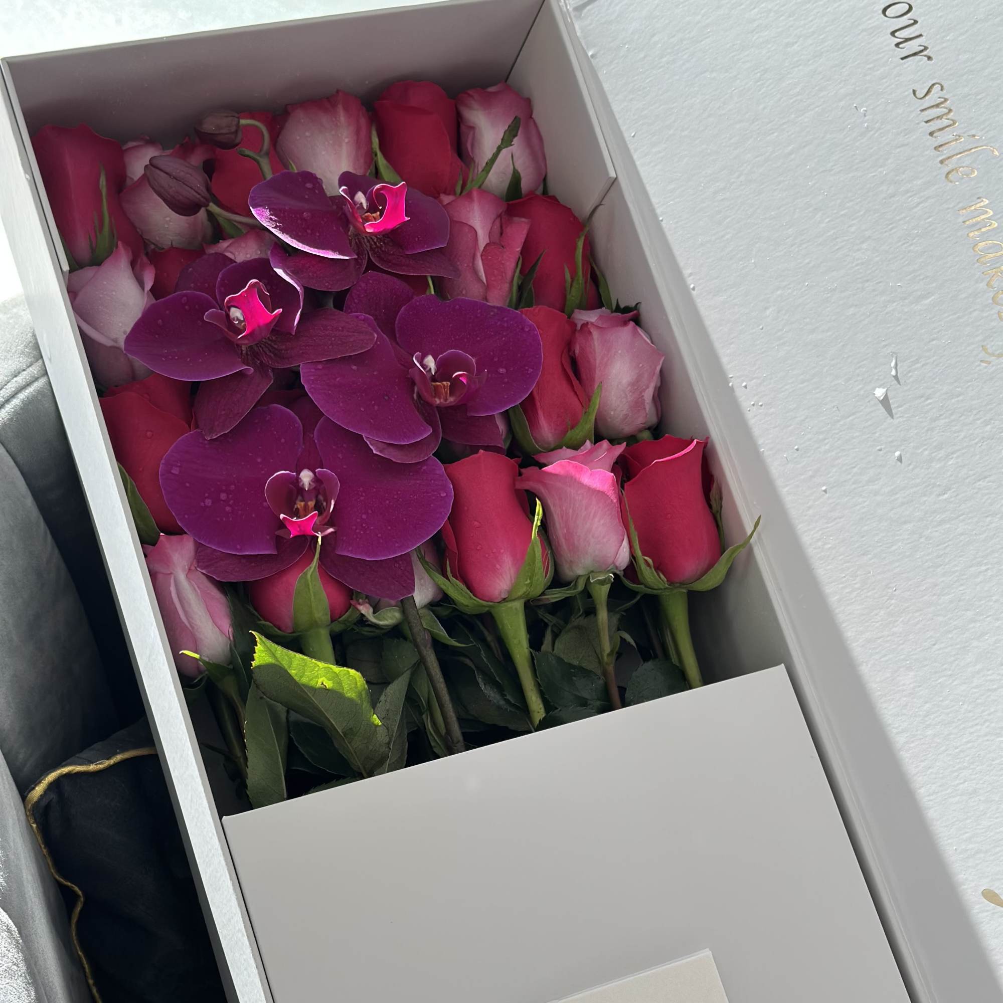 Box of pink roses and purple orchids