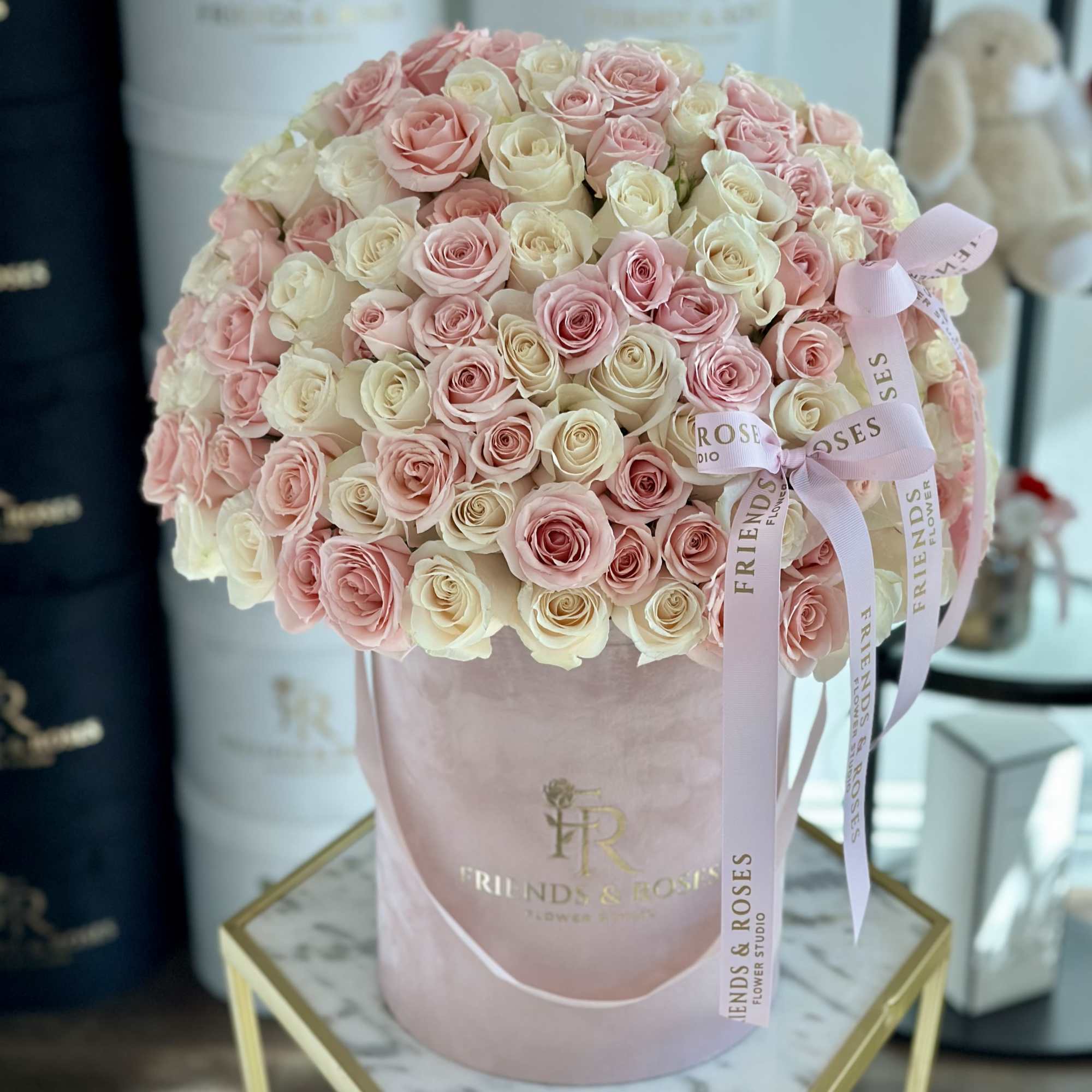 Large bouquet of pink and cream roses in a pink hatbox with ribbon