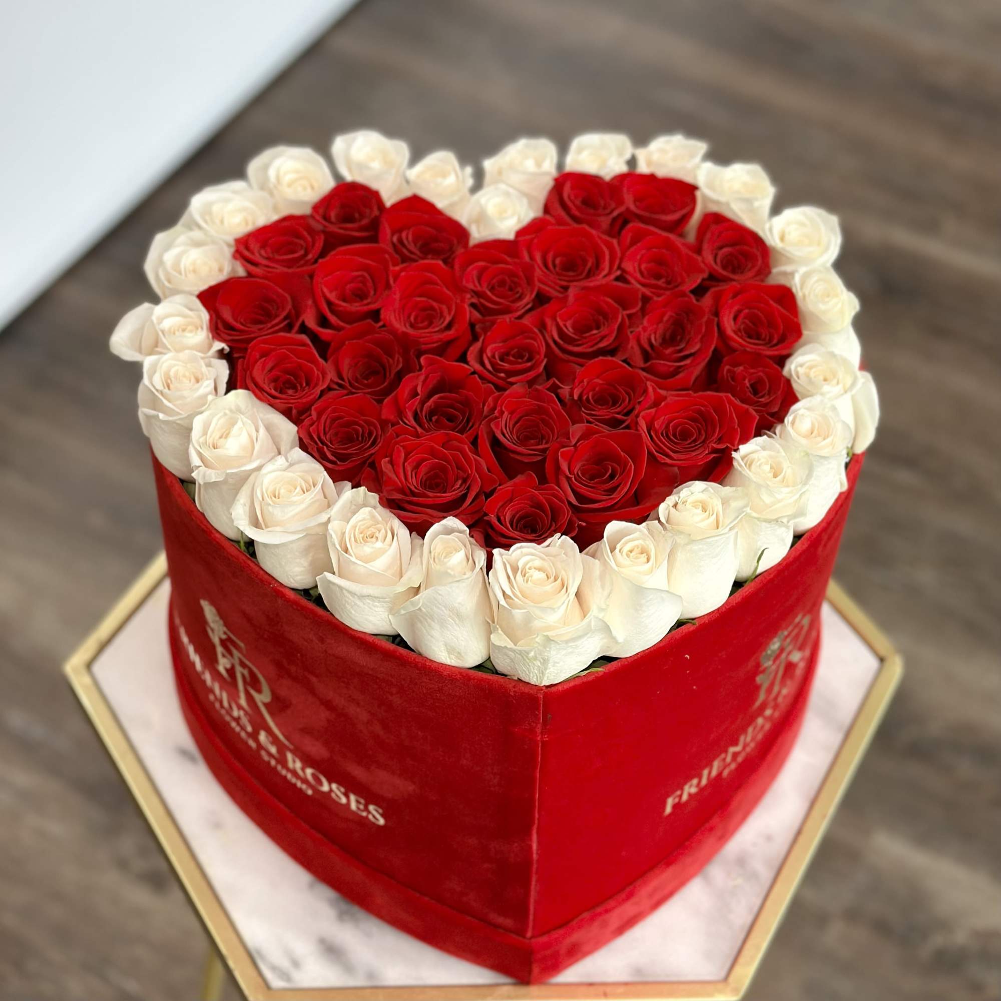 Heart-shaped box filled with red and white roses