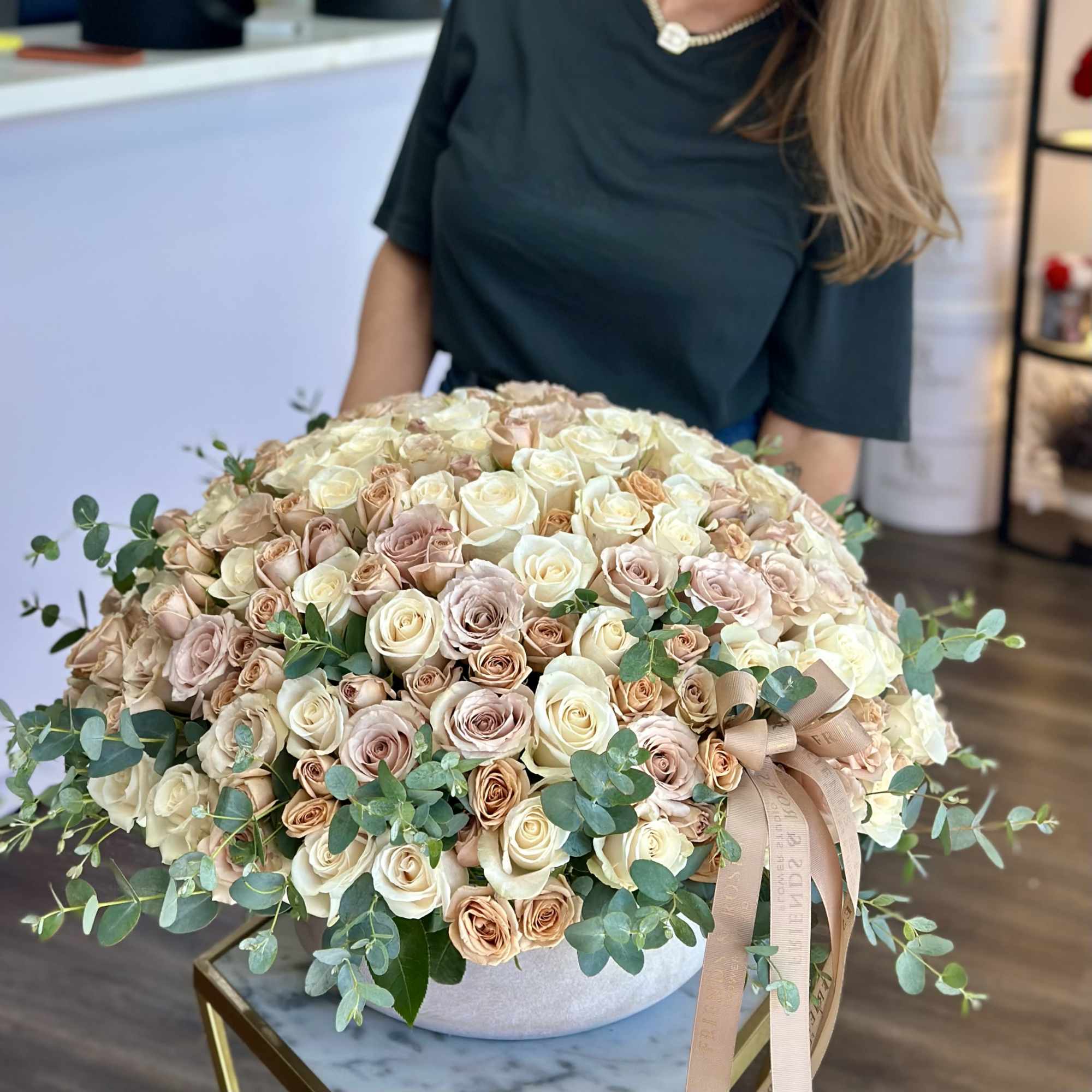 Large bouquet of cream and blush roses with eucalyptus in a round box