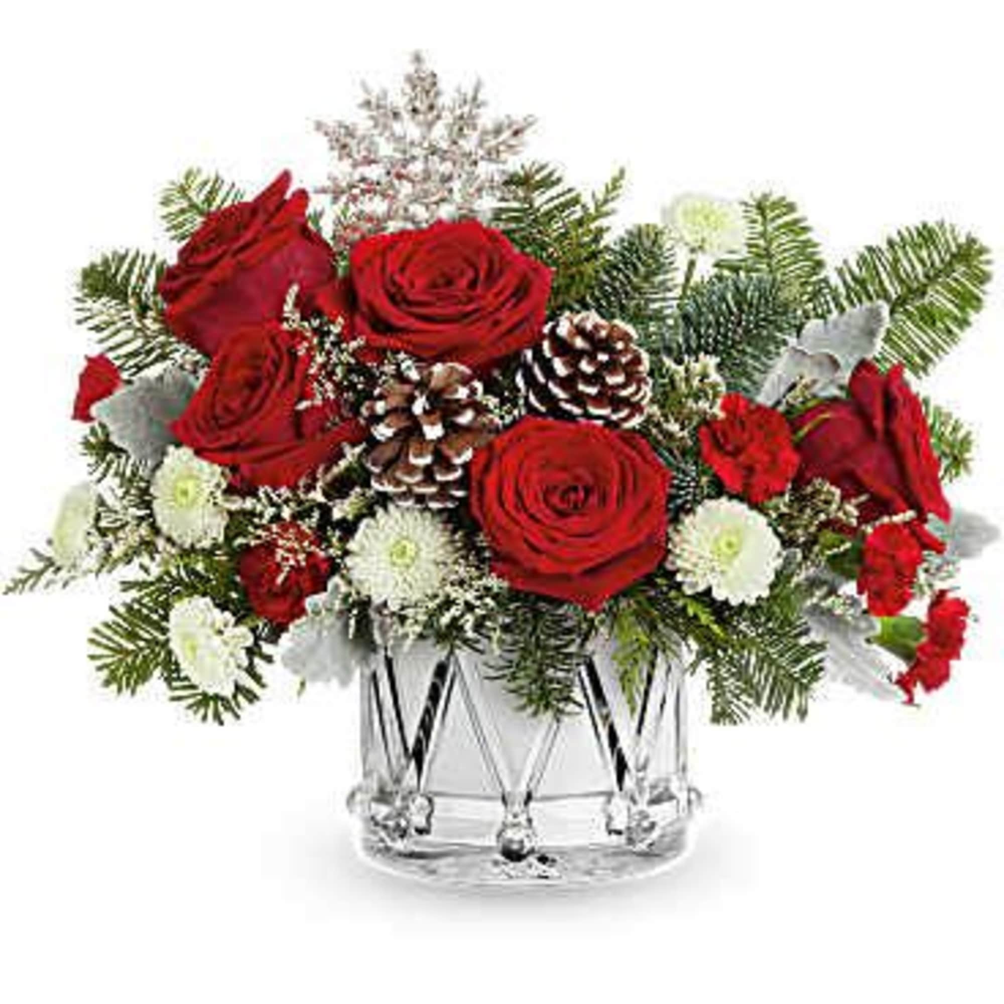 Red roses and white flowers arranged in a clear glass vase