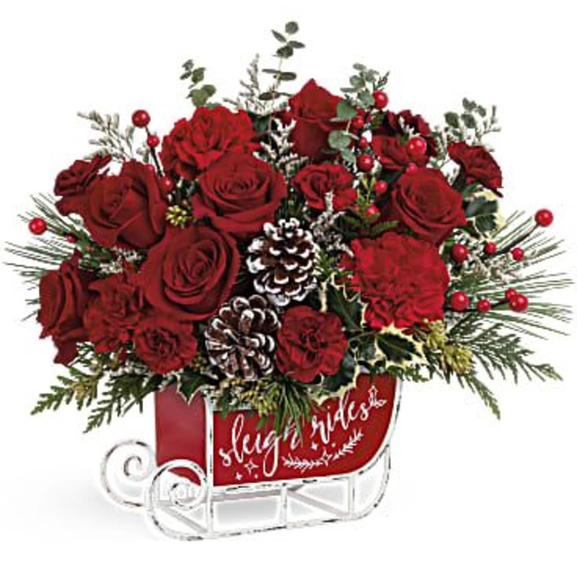 Red roses arranged in a sleigh-shaped container with pinecones and berries