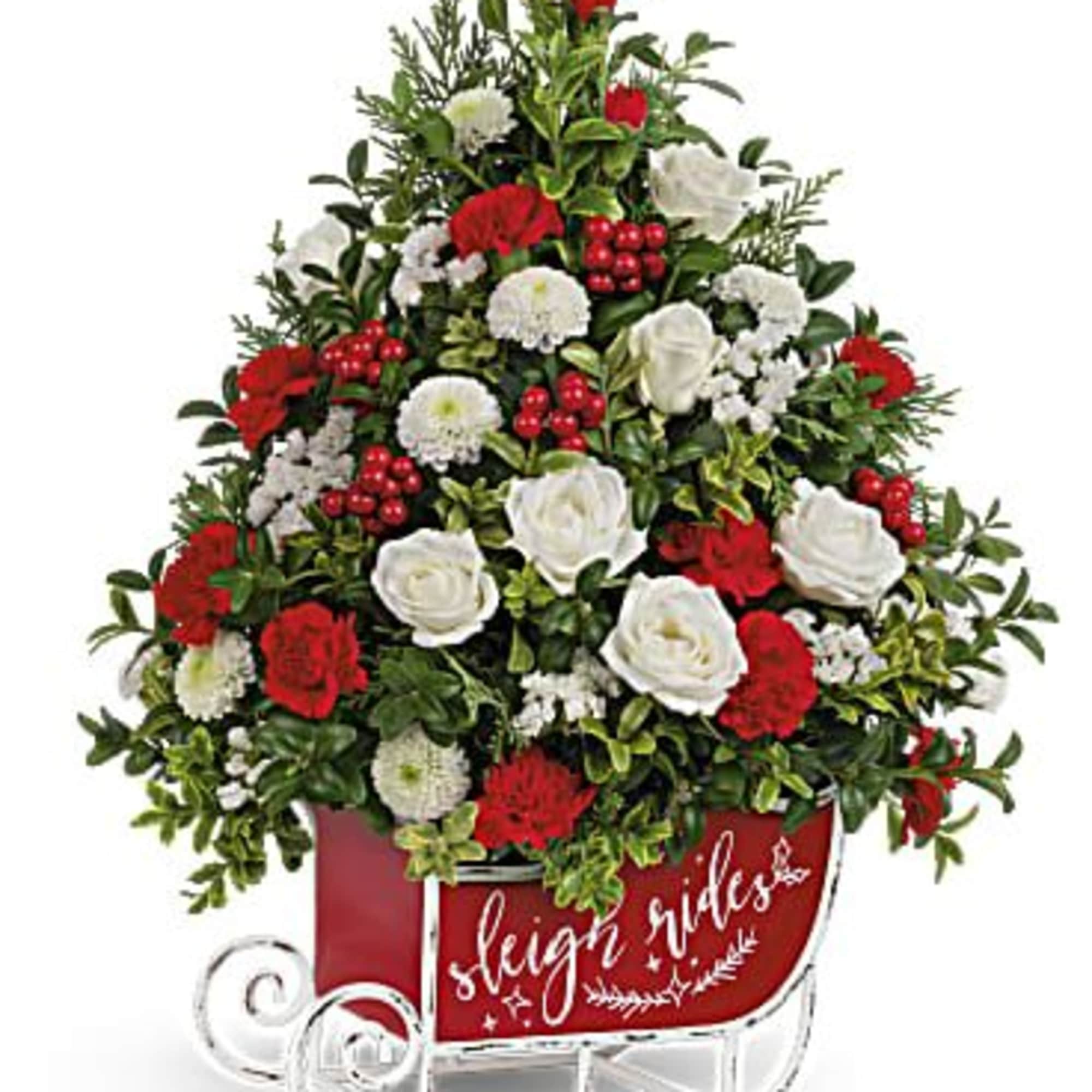 Red and white floral arrangement in a sleigh-shaped container