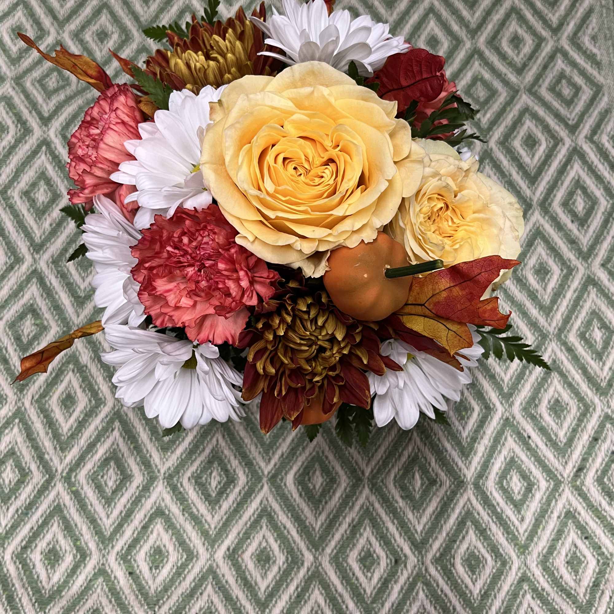 Compact bouquet of yellow roses, white daisies, and red carnations