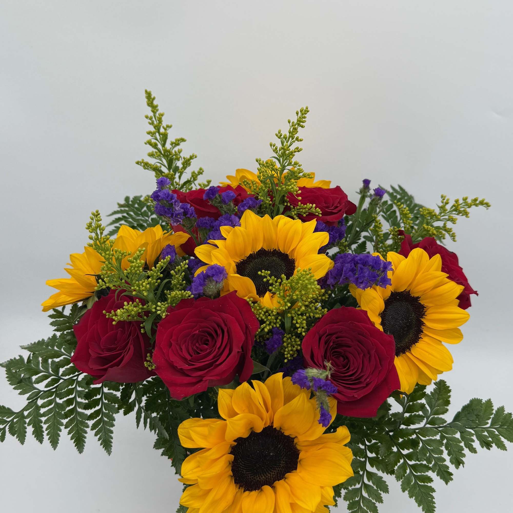 Bouquet of red roses and yellow sunflowers with purple filler flowers