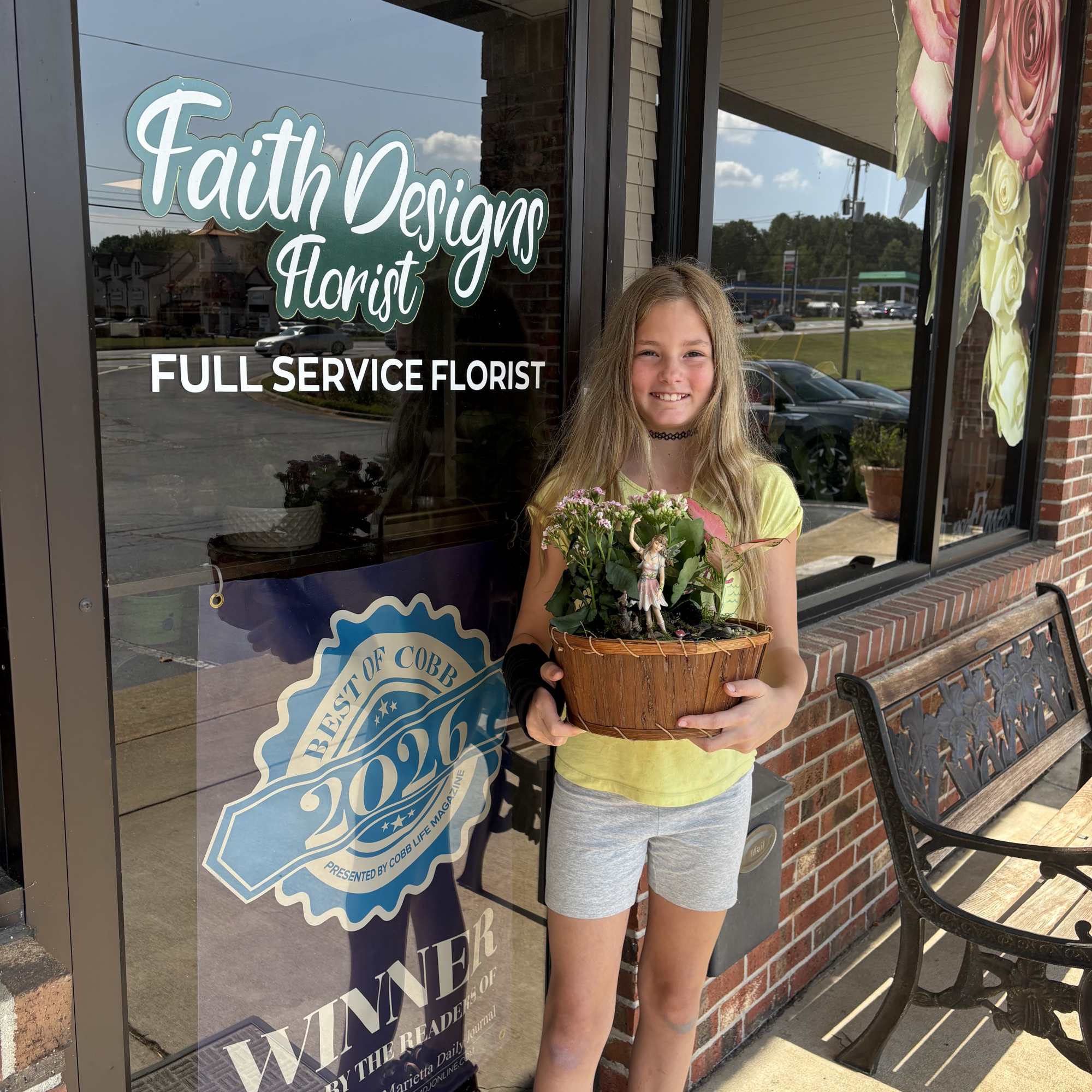Girl holding a small flower basket outside a florist shop