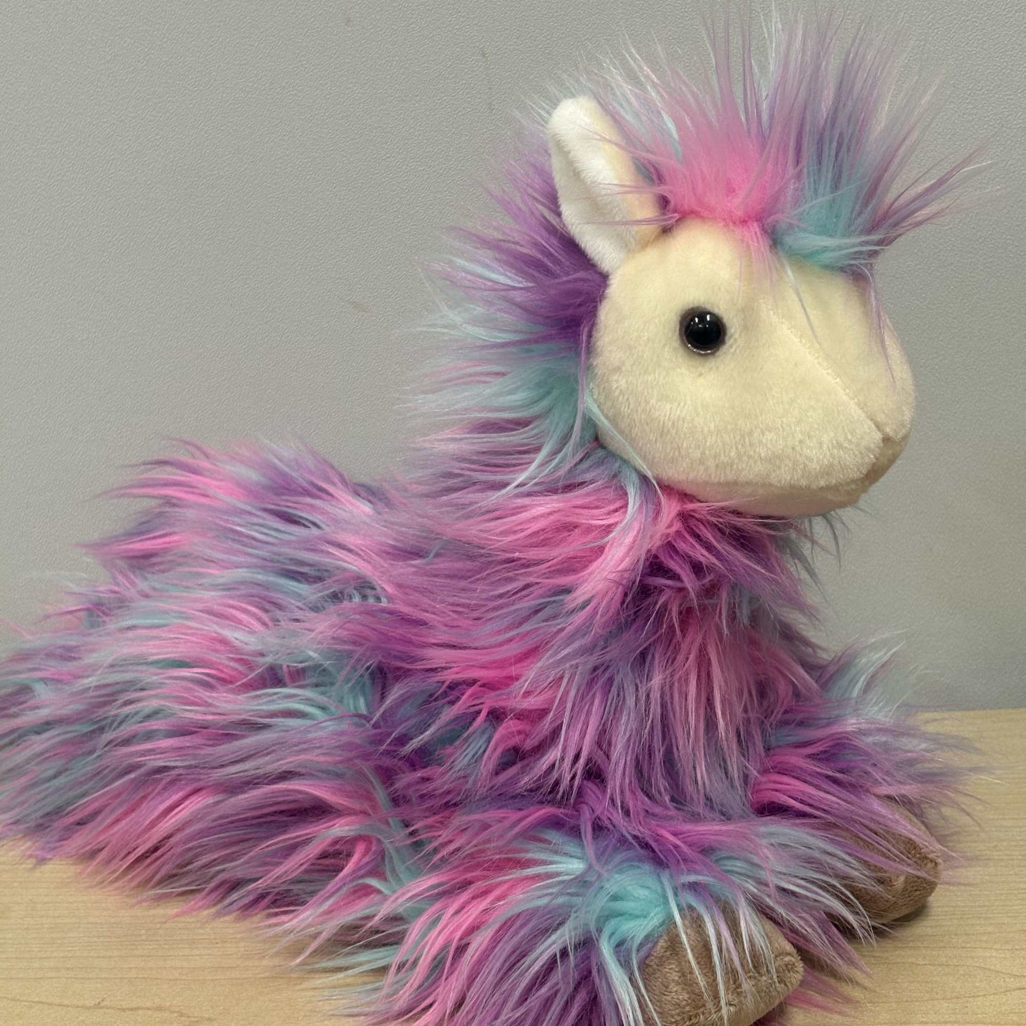Plush unicorn with long pink, purple, and blue fur