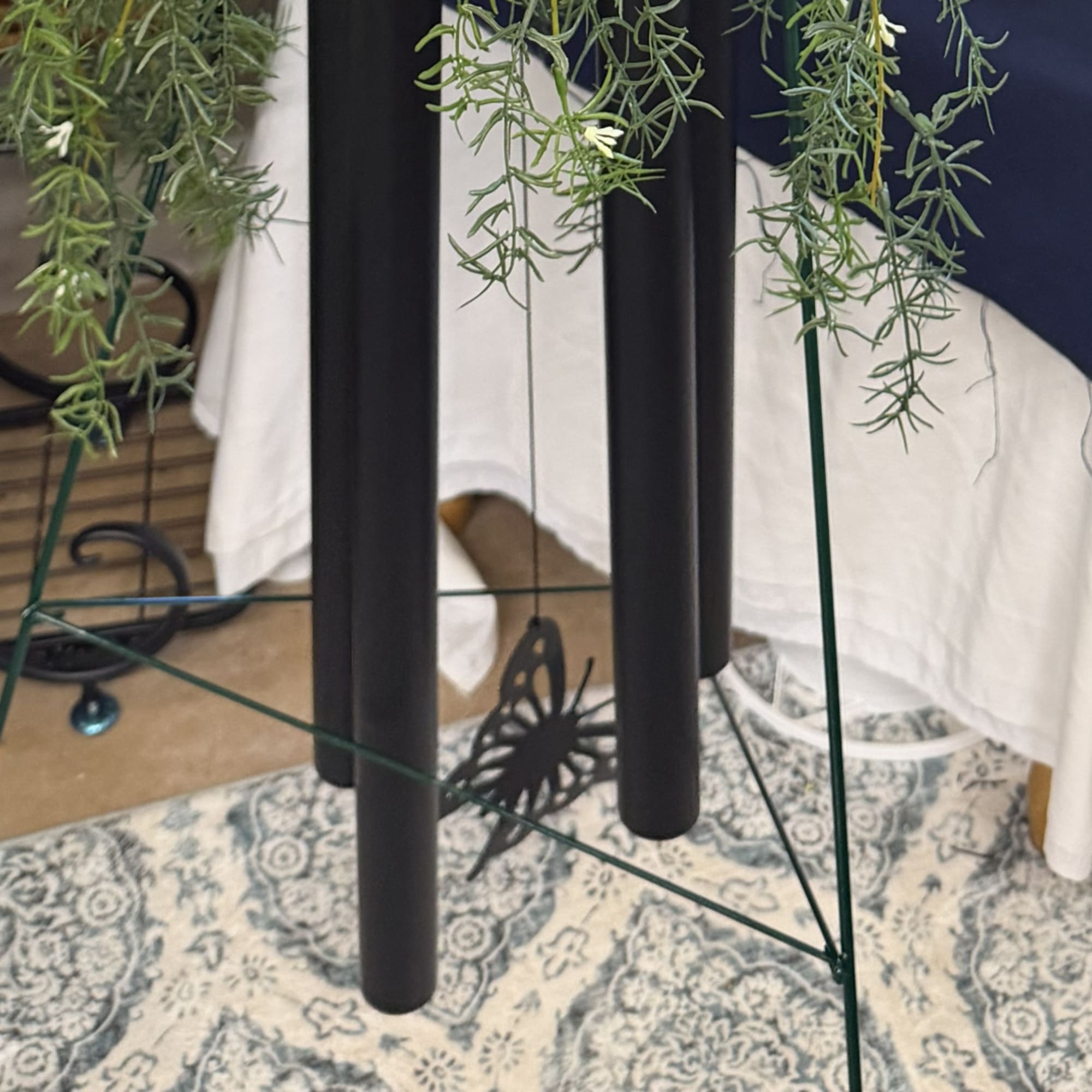 Hanging greenery on a black metal stand above a patterned rug