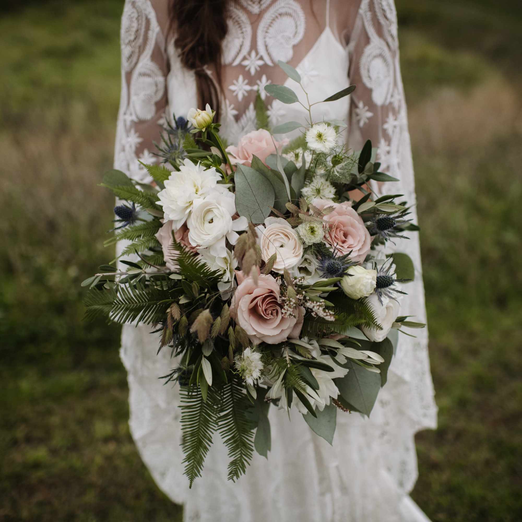 Bride holding a bouquet of blush and white flowers