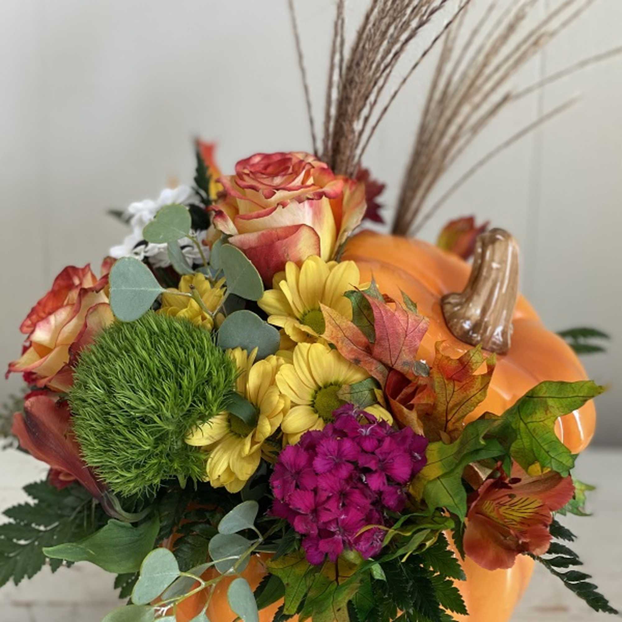 Bright fall flowers, leaves and more fill a hand-painted ceramic pumpkin that, photo 3 of 3