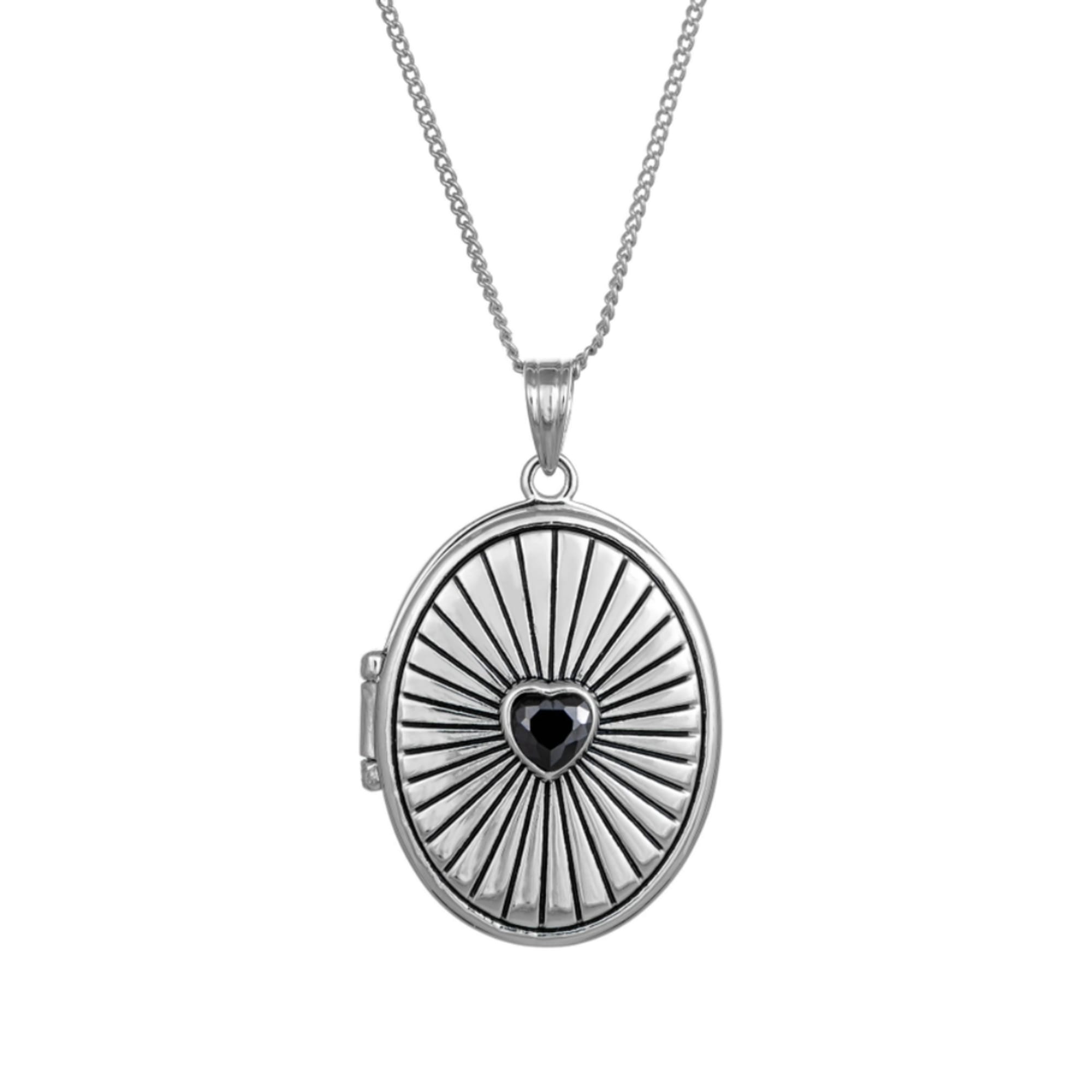 Silver locket necklace with a black heart center on a white background