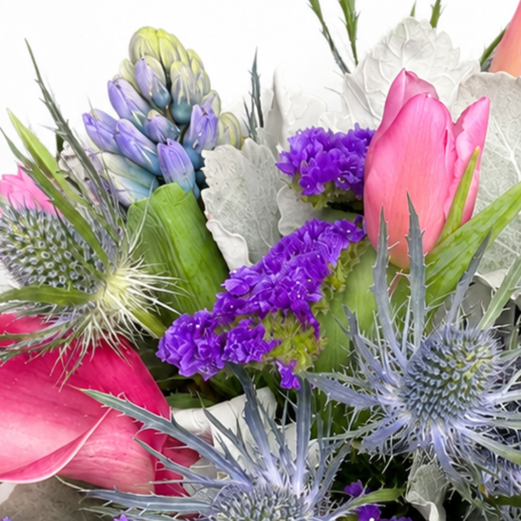 Colorful bouquet with pink tulips, purple blooms, and spiky blue thistles
