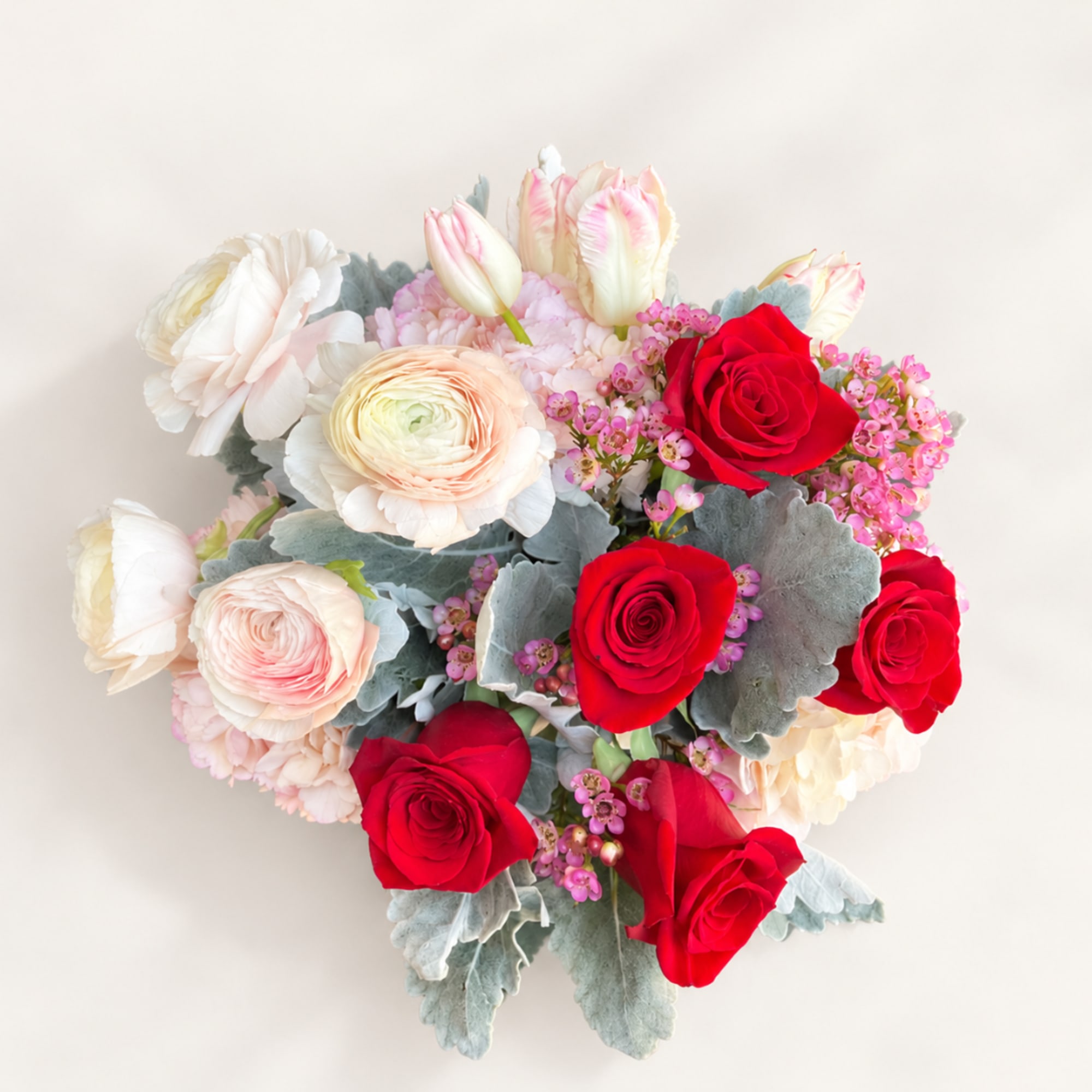 Bouquet of red and blush roses with pale tulips and ranunculus