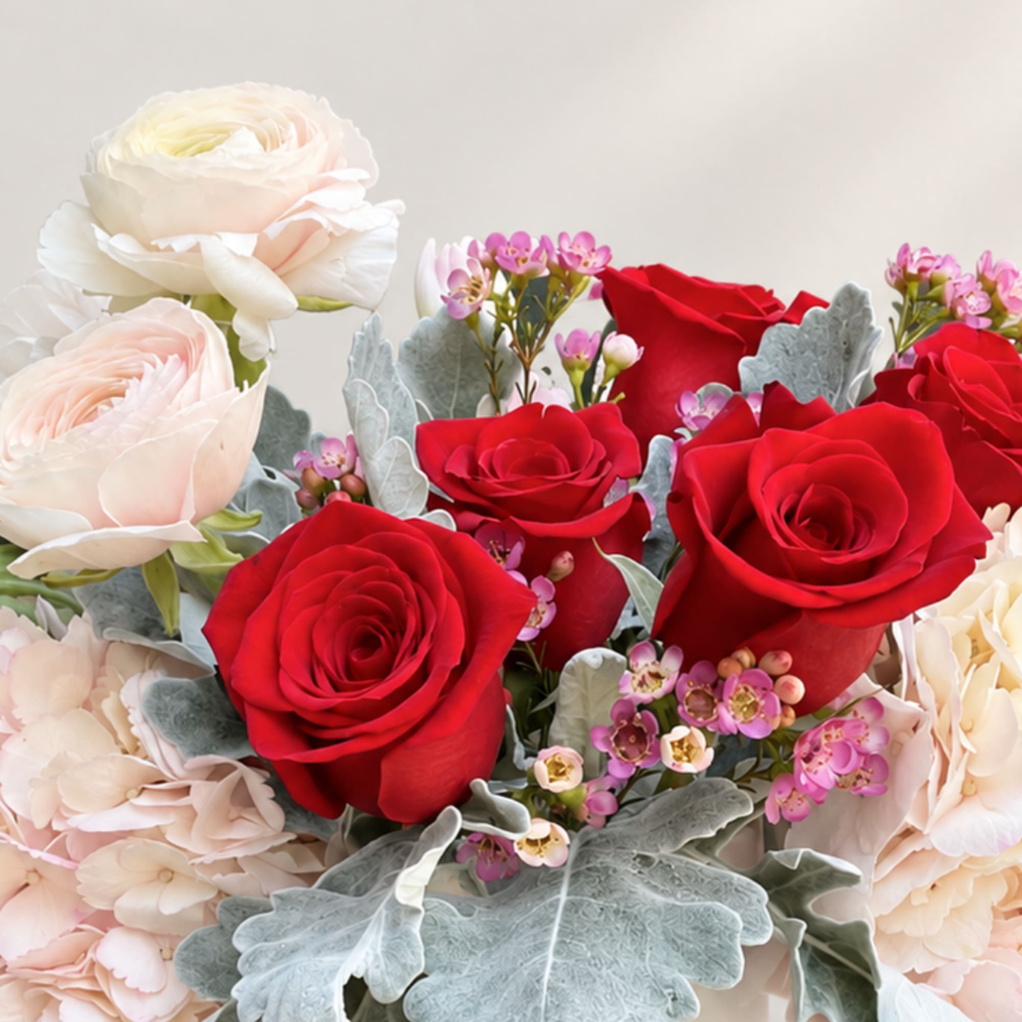 Bouquet of red and pale blush roses with small pink filler flowers