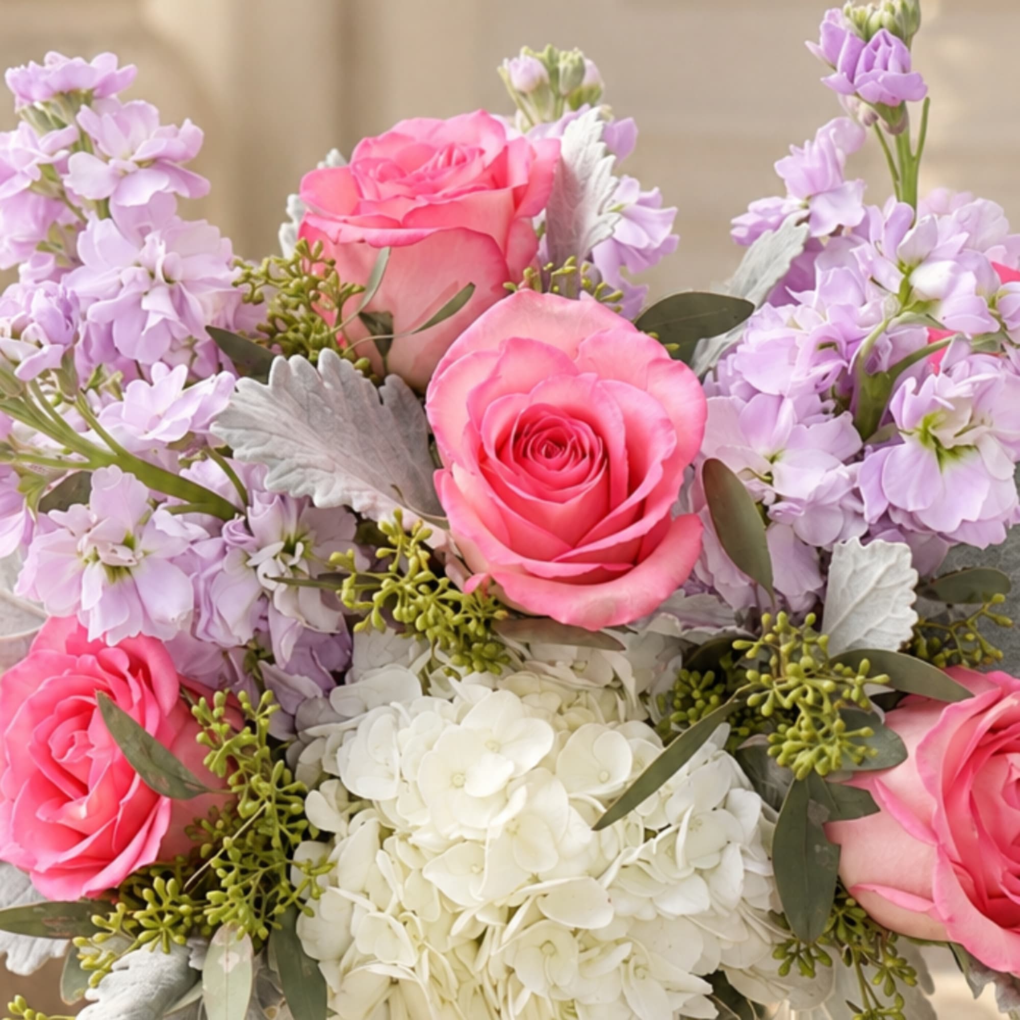 Pink roses and lavender flowers arranged with white hydrangea