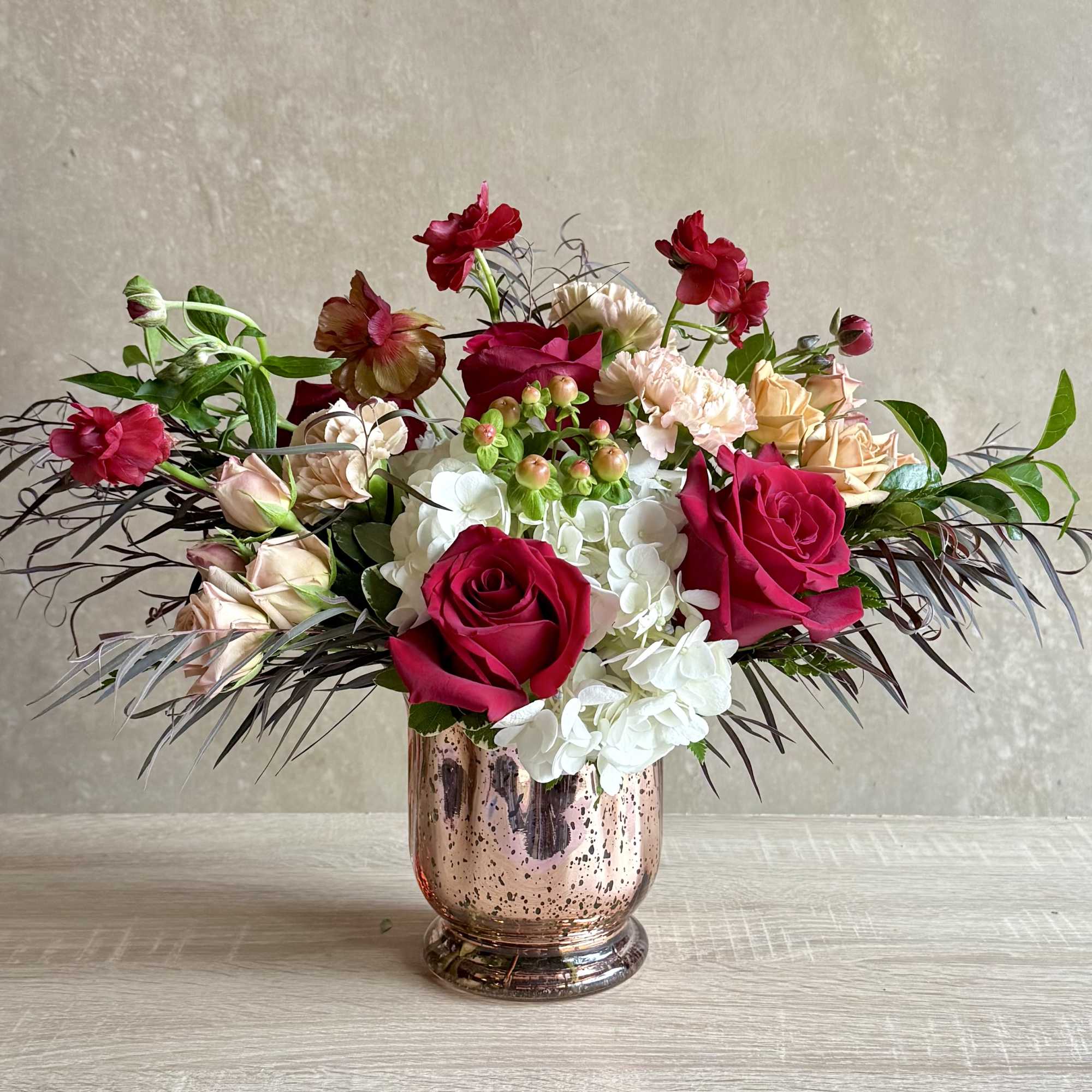 Mixed bouquet of roses and hydrangeas in a metallic vase
