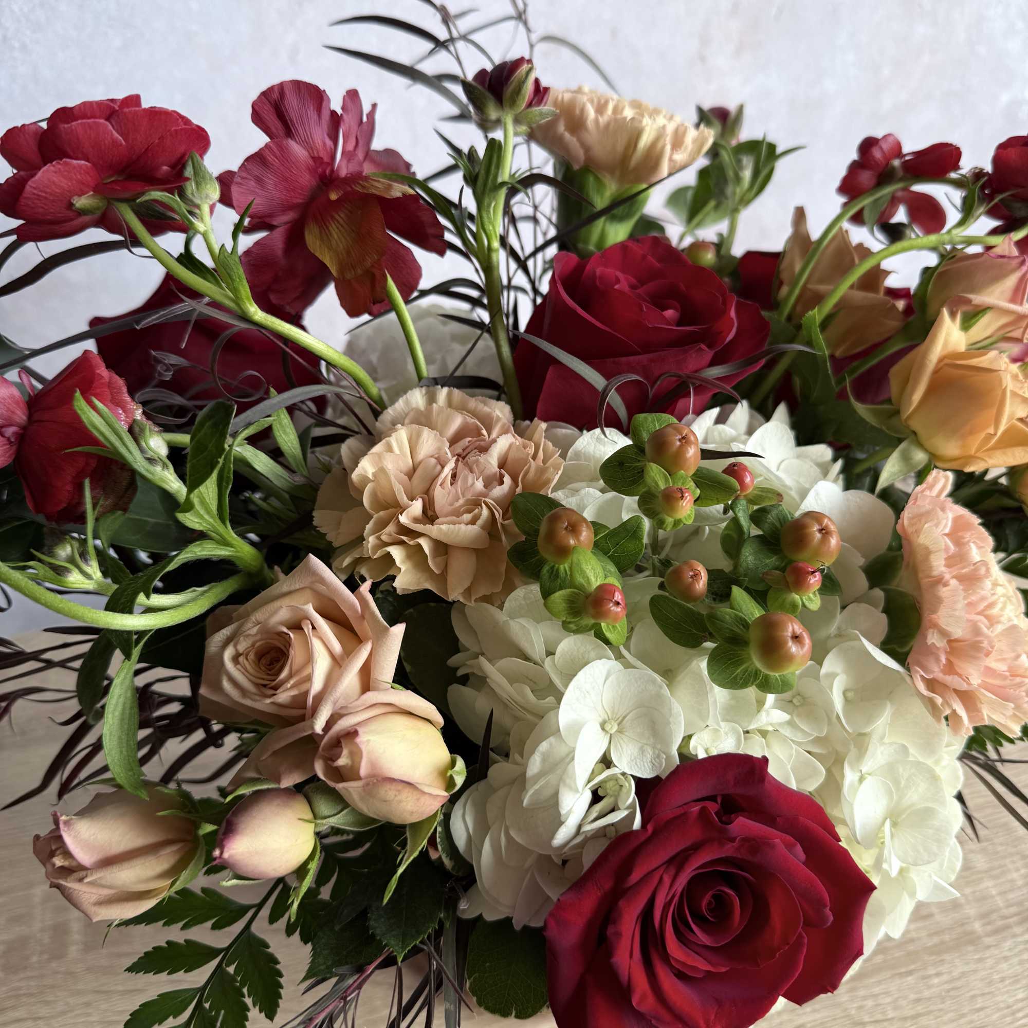 Bouquet of red and blush roses with white hydrangea and carnations