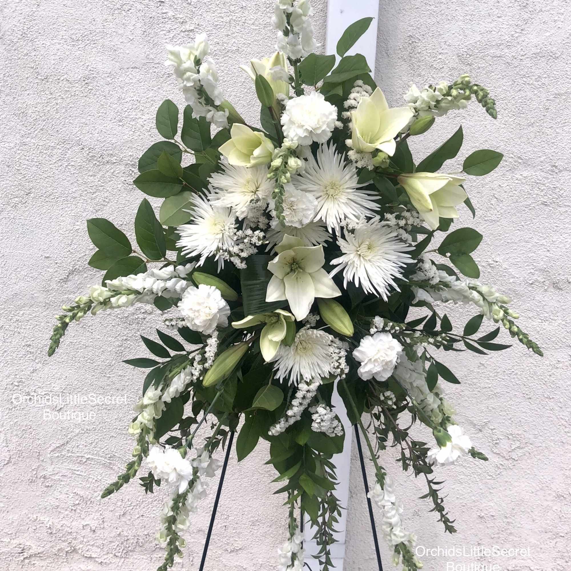 White floral standing spray on a black easel, photo 2 of 2