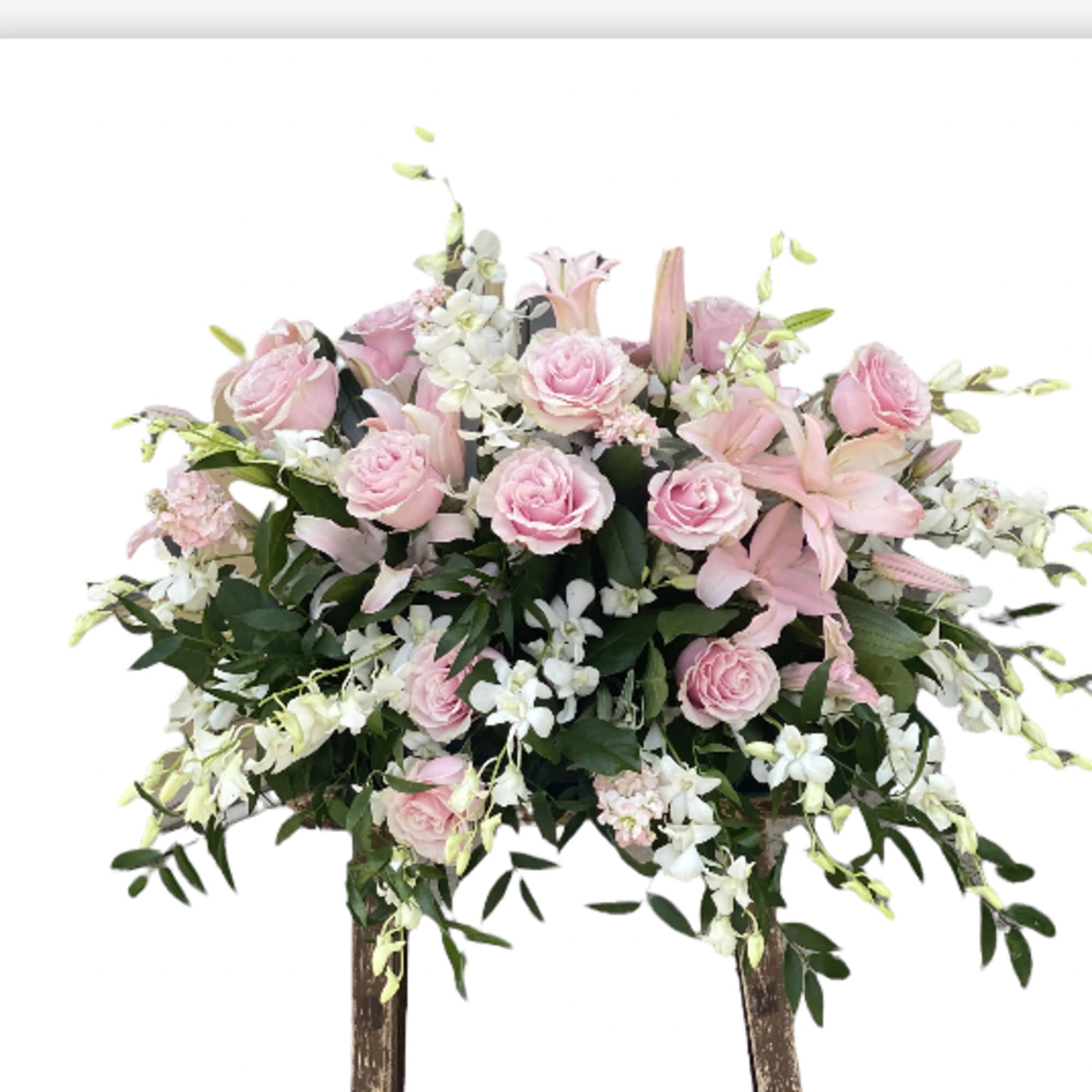 Pink roses and lilies arranged on a standing easel display